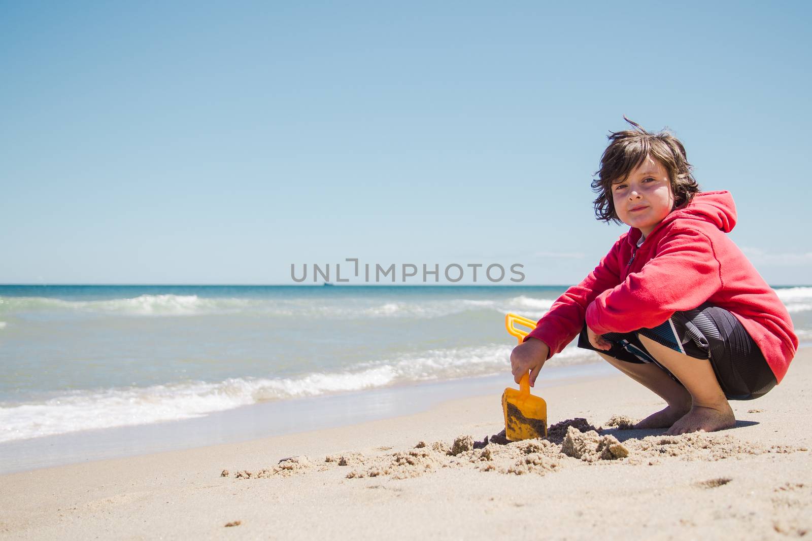 Boy playing in the sand by Talanis