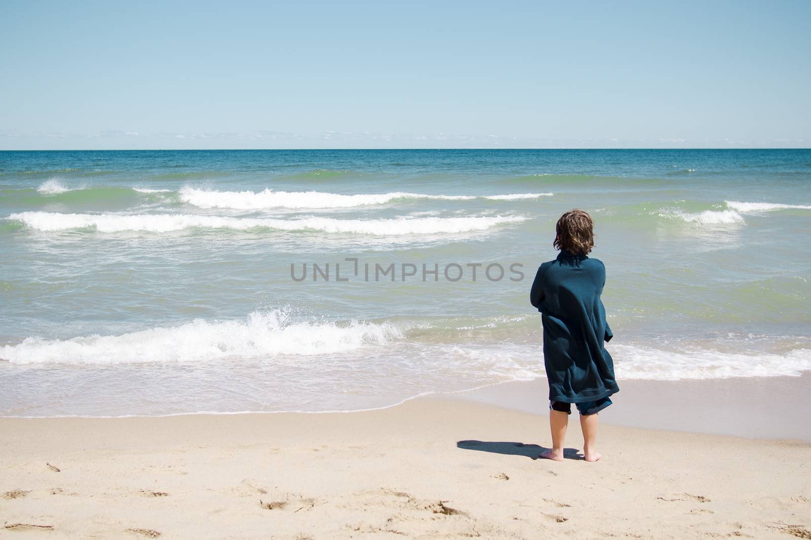 Boy standing on the beach and relaxing in Cape Cod