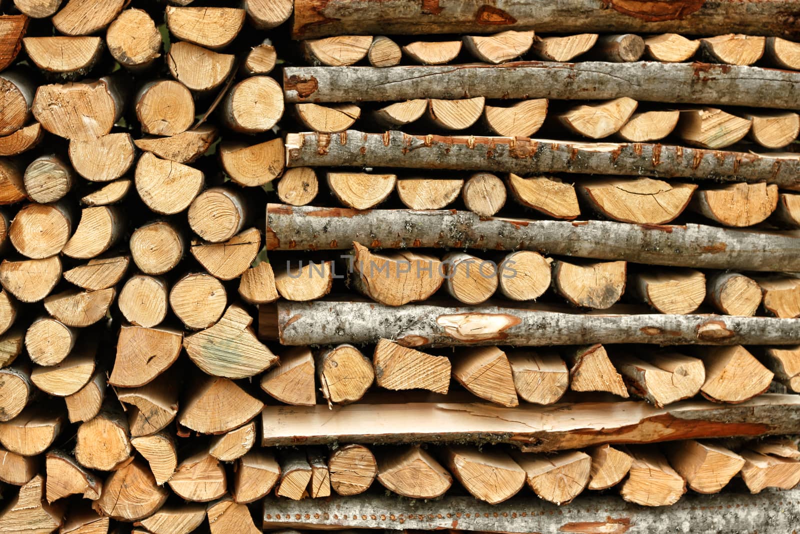 Cut and split firewood stacked in heap pile natural energy