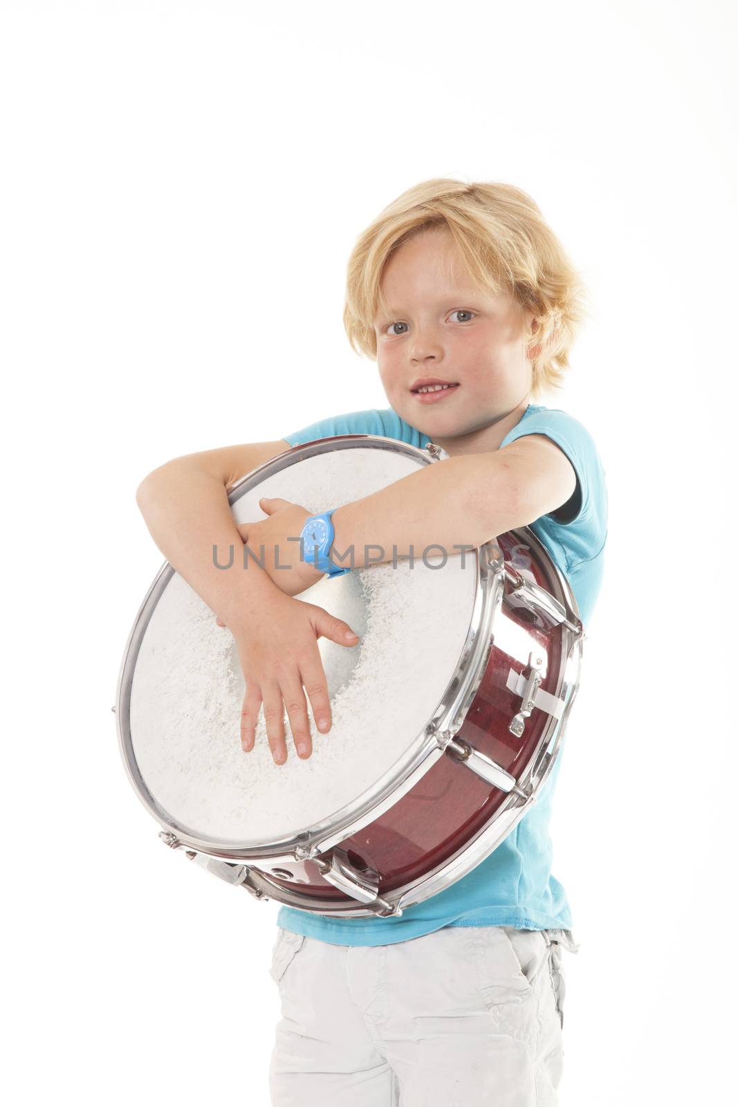 young blond boy holding drum against white background