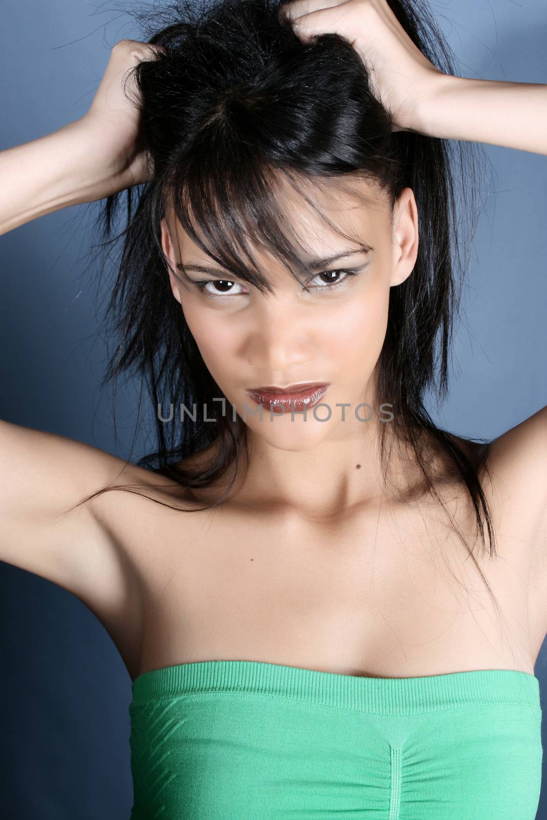 Frustrated brunette female model against a blue background