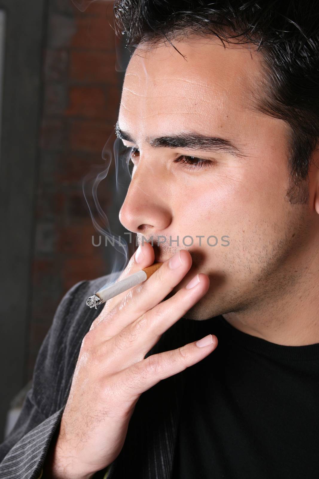 Brunette male model against a brickwall background