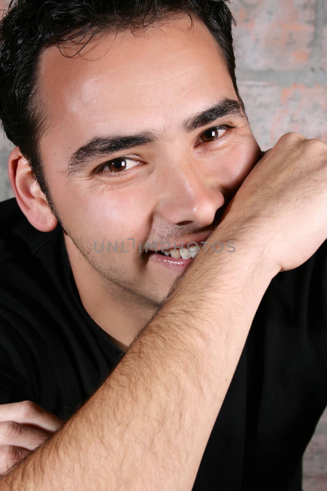 Brunette male model against a brickwall background