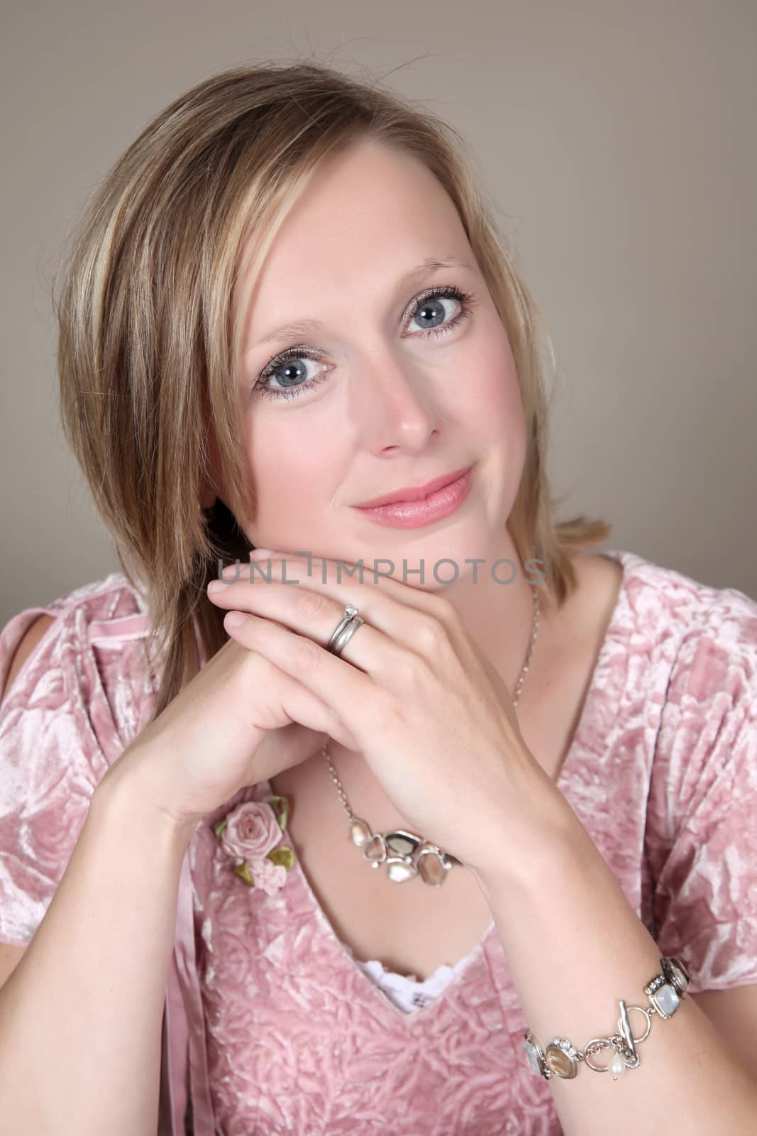 Portrait shot of beautiful blond woman against a brown background