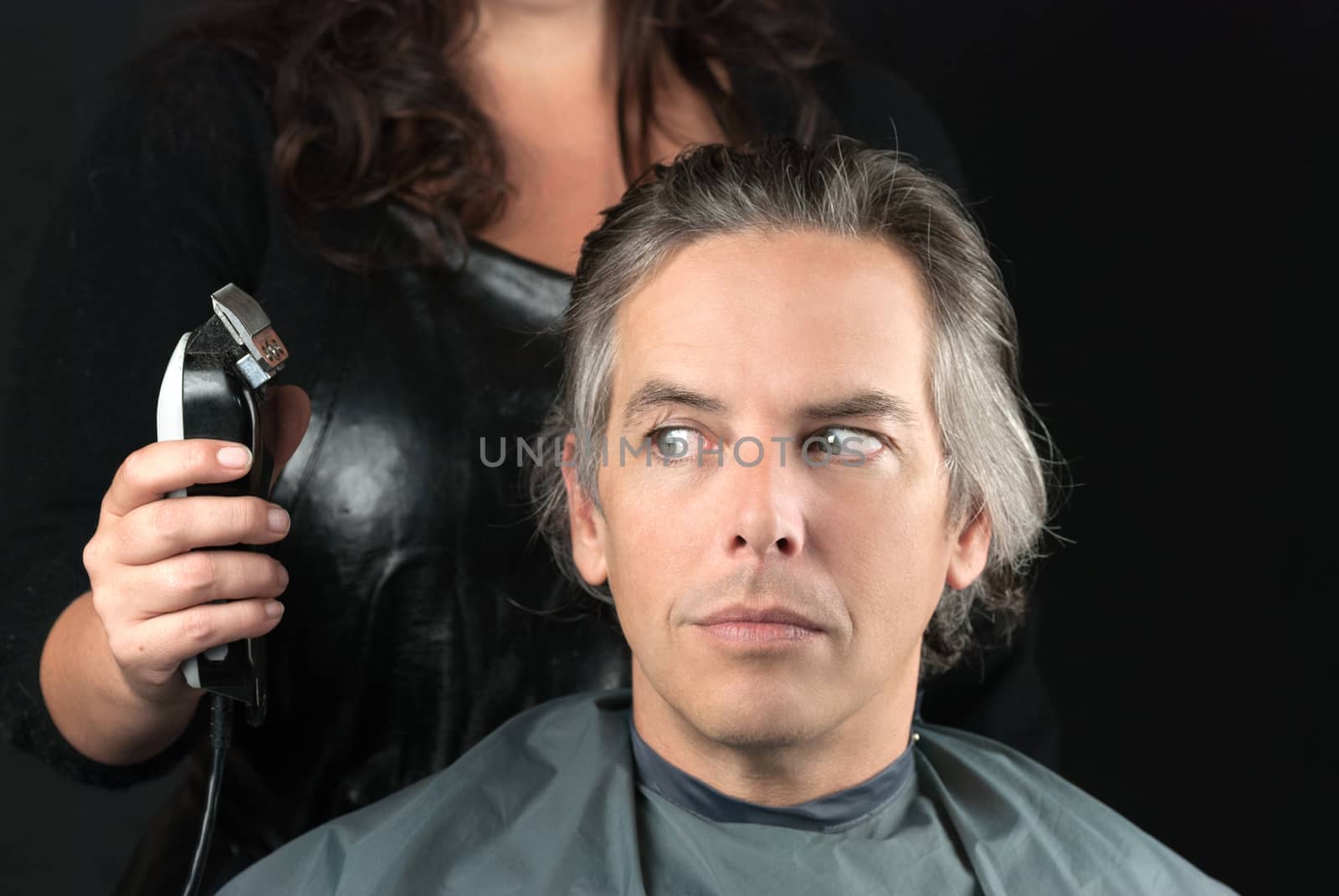 Close-up of a hair stylist preparing to use clipper having removed bulk length.