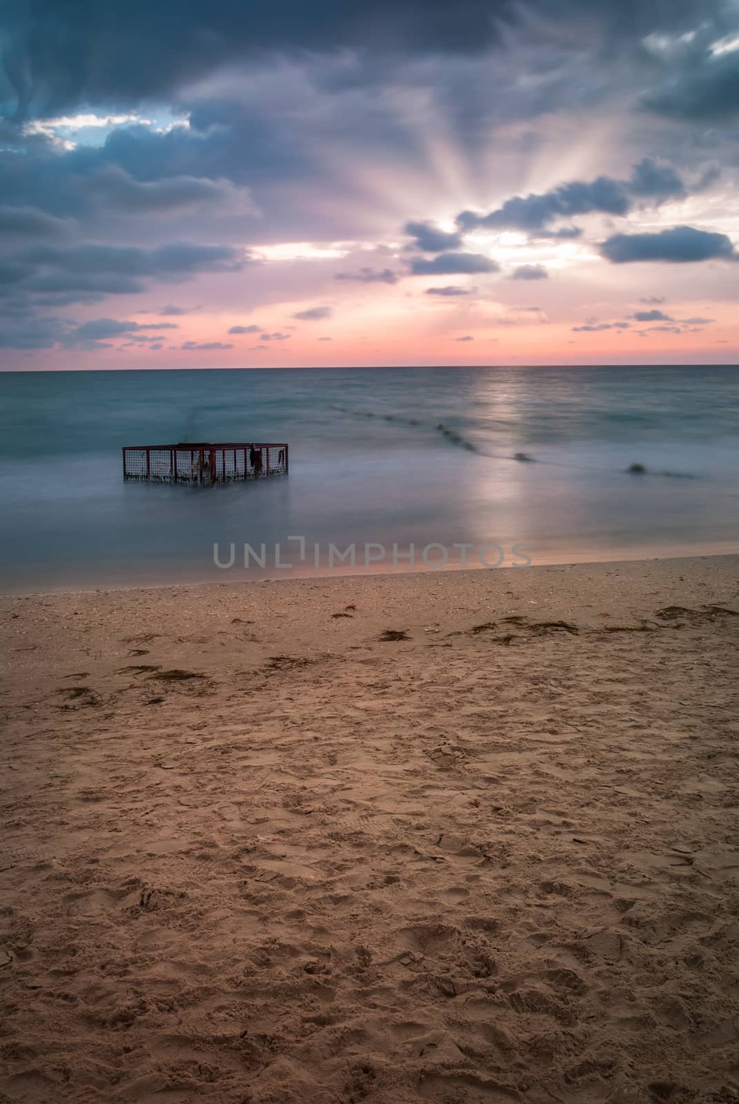 Tropical Beach with Empty Cage in the Sea at Sunset by Kayco