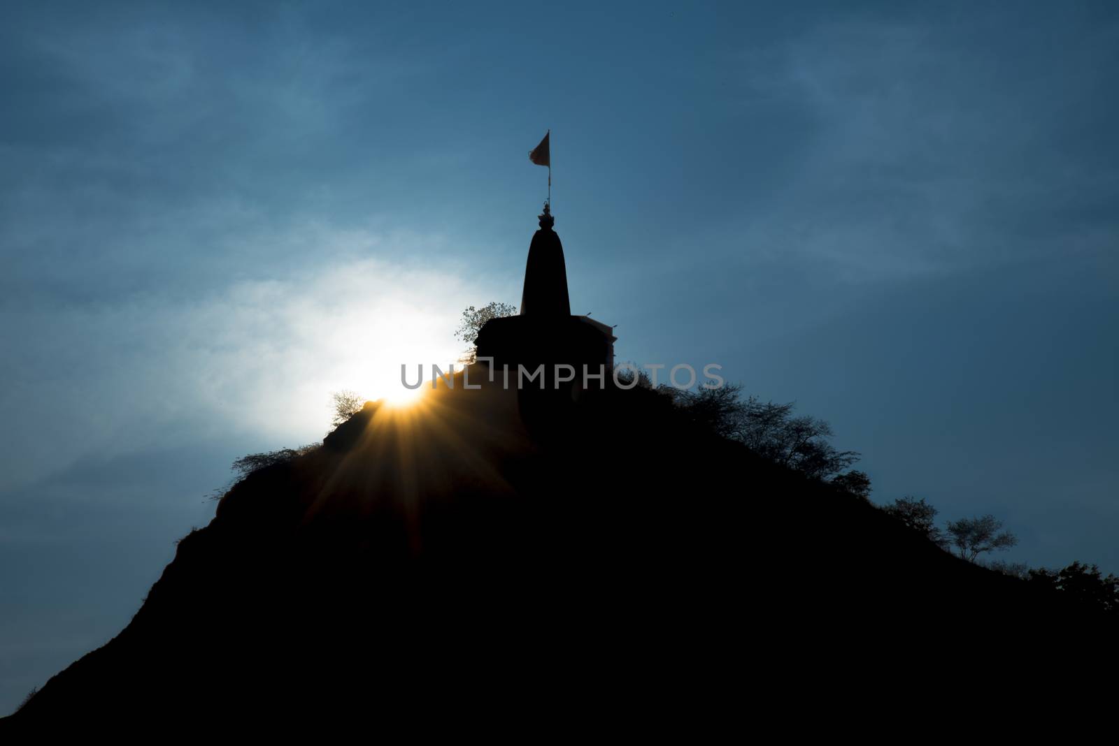 Sun setting over a hill temple in Rajasthan India
