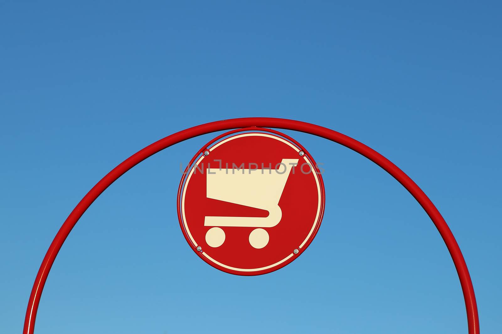 Shopping cart sign against blue sky