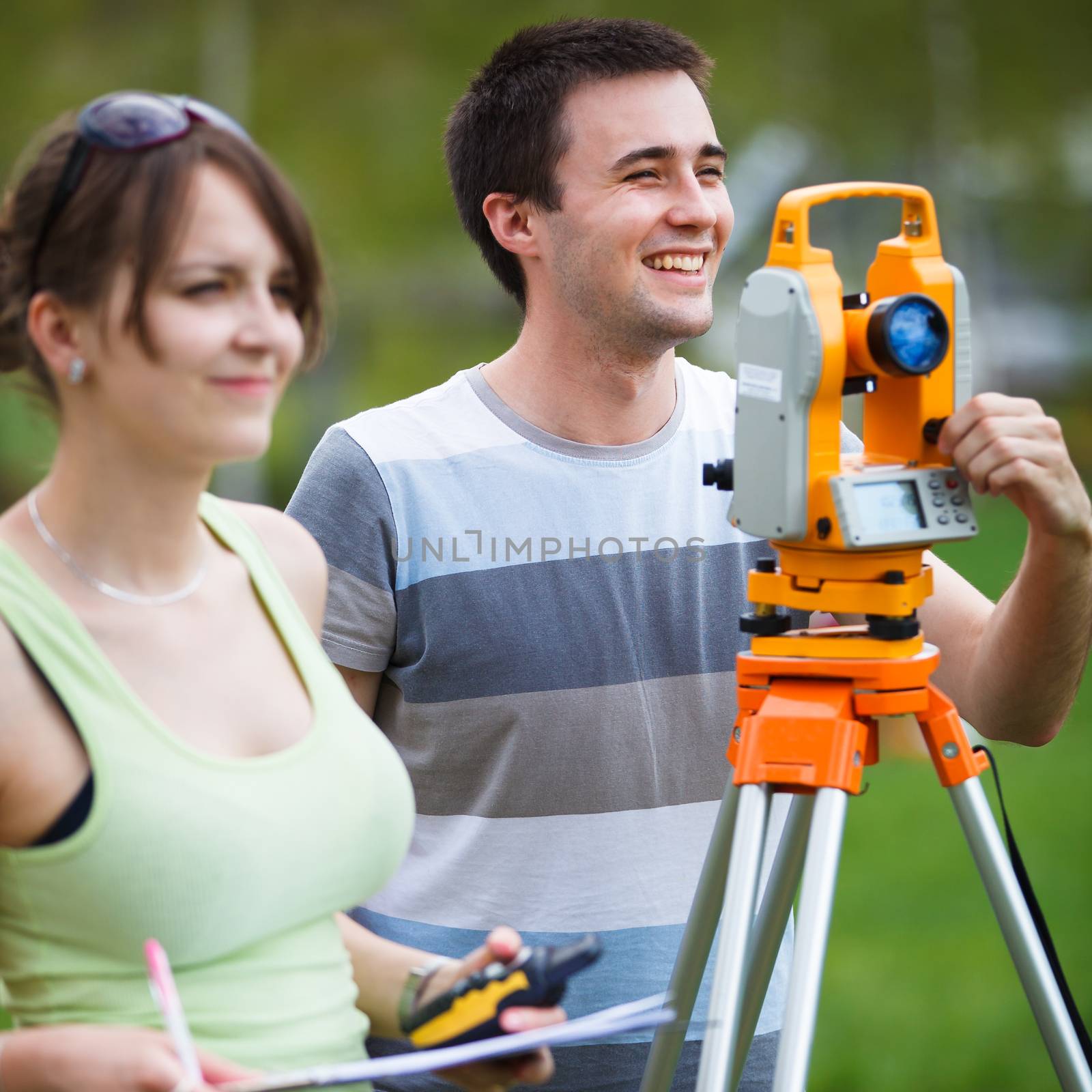 Two young land surveyors at work by viktor_cap