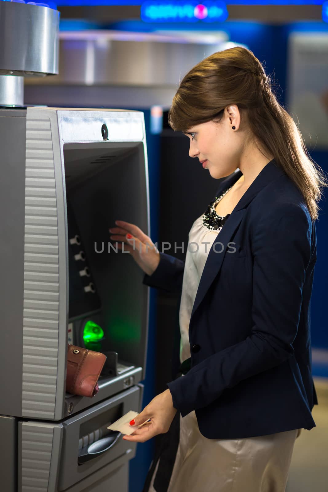 Pretty, young woman withdrawing money from her credit card by viktor_cap