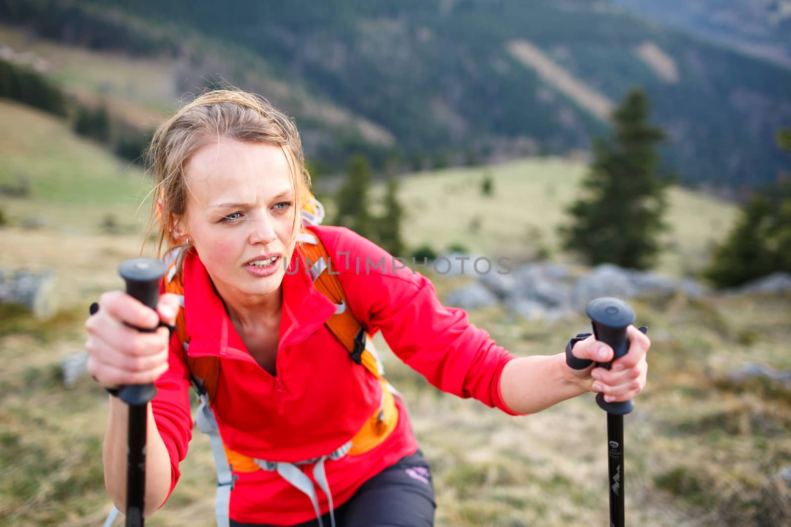 Pretty, young female hiker having a tough walk uphill