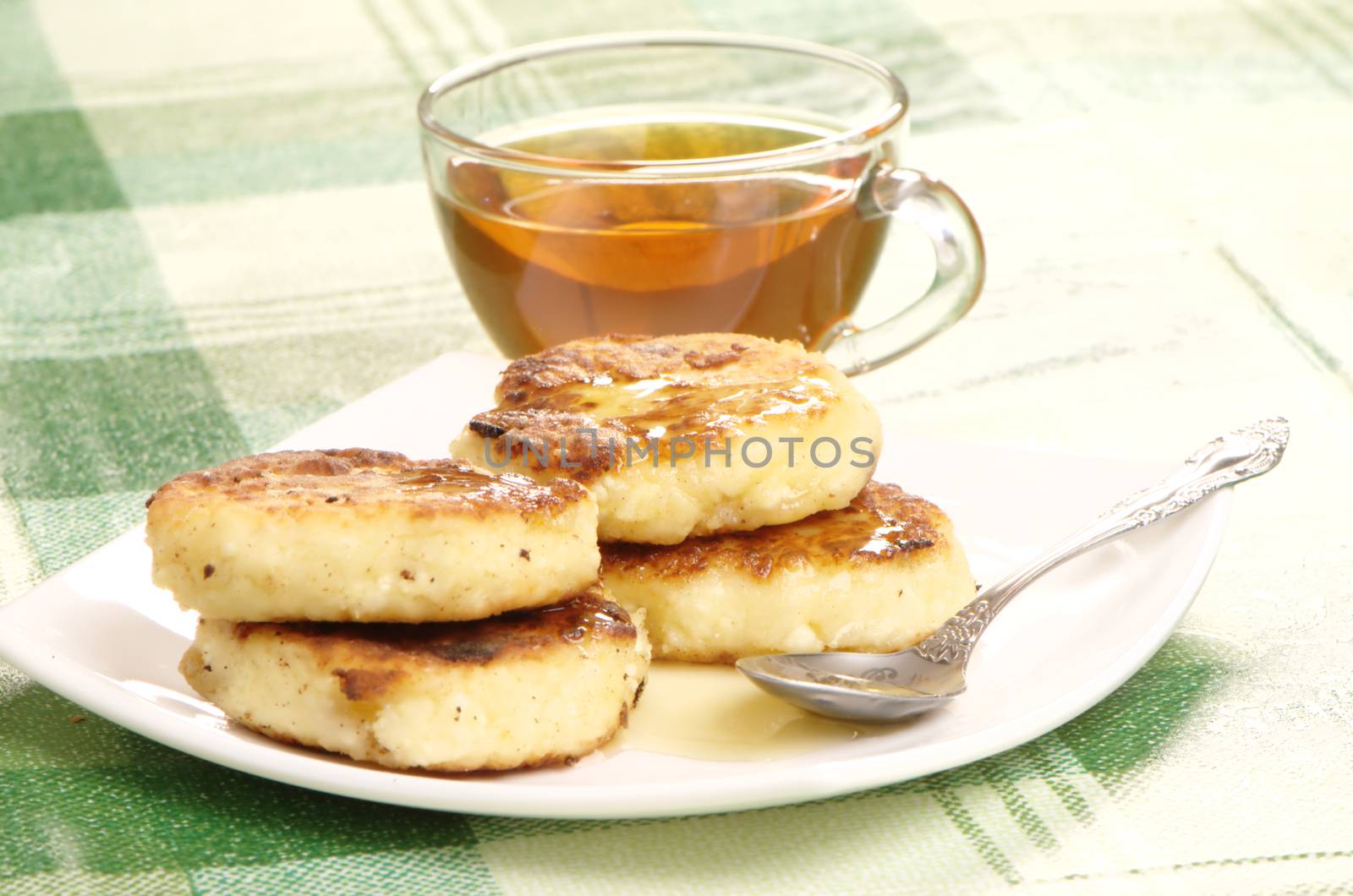 Delicious homemade cheese pancakes with honey closeup