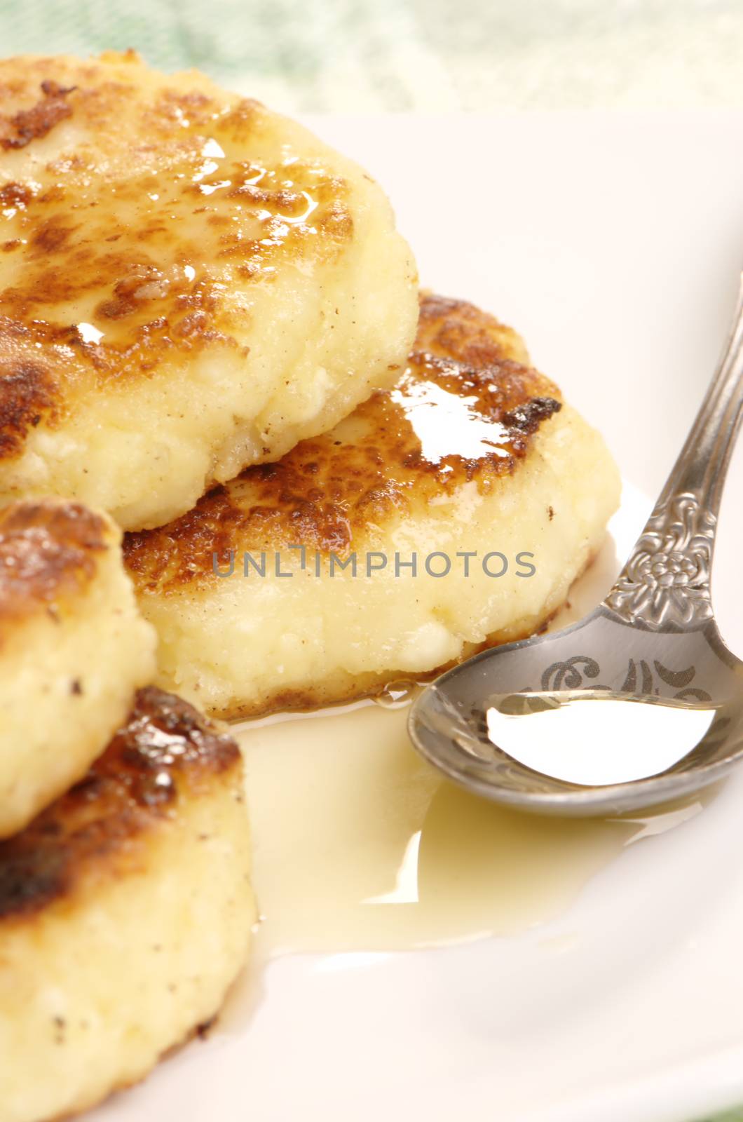 Delicious homemade cheese pancakes with honey closeup