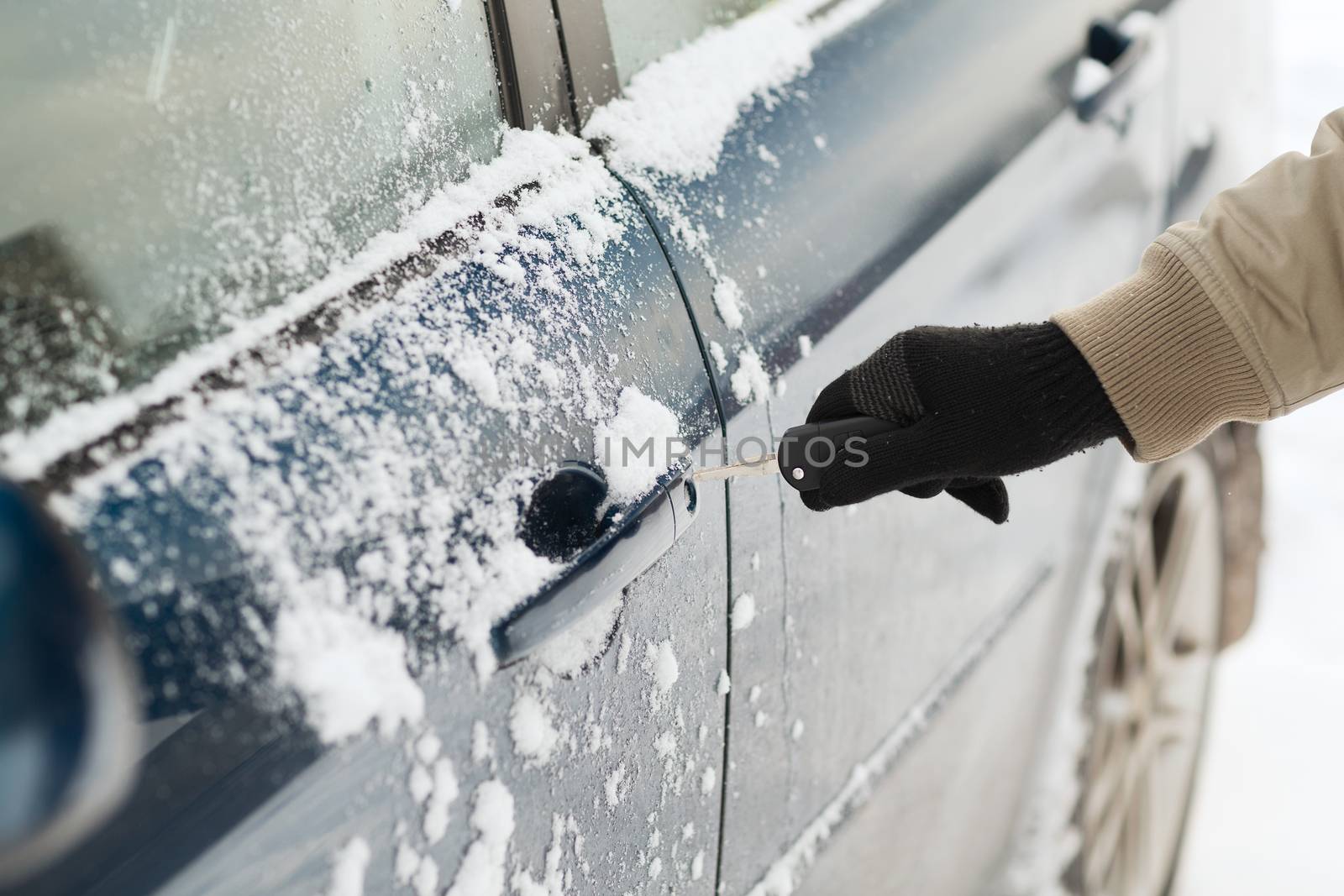 transportation and ownership concept - closeup of man hand opening car with key