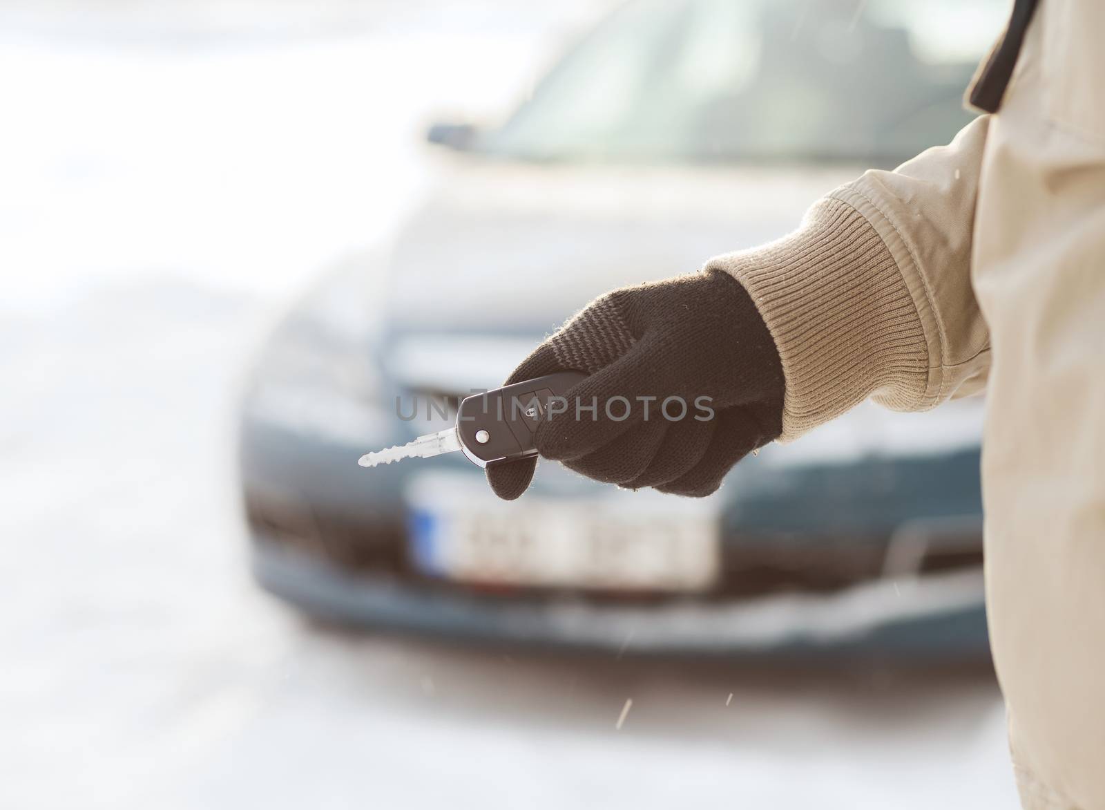 closeup of man hand with car key outdoors by dolgachov