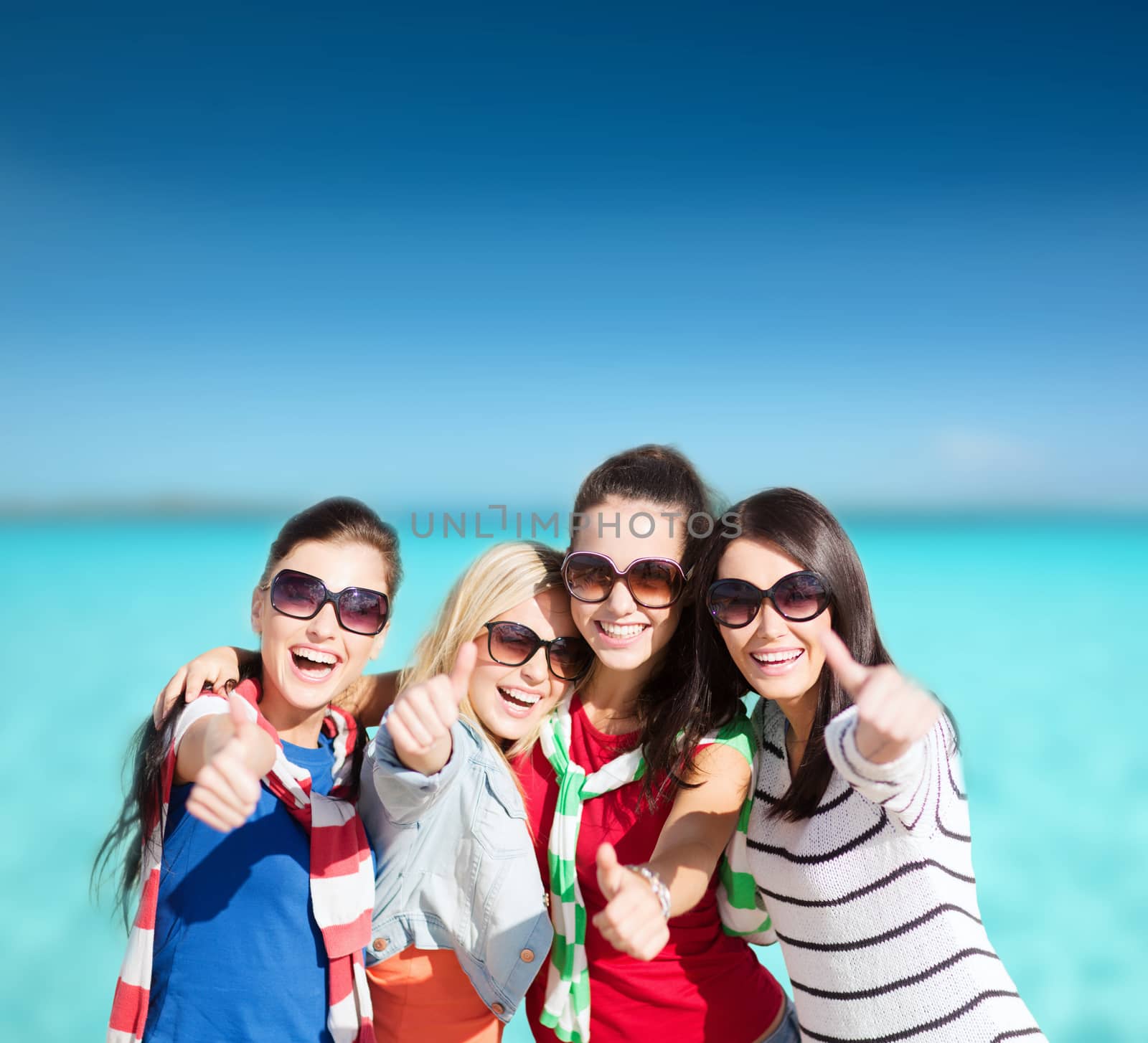 summer, holidays, vacation, happy people concept - beautiful teenage girls or young women showing thumbs up