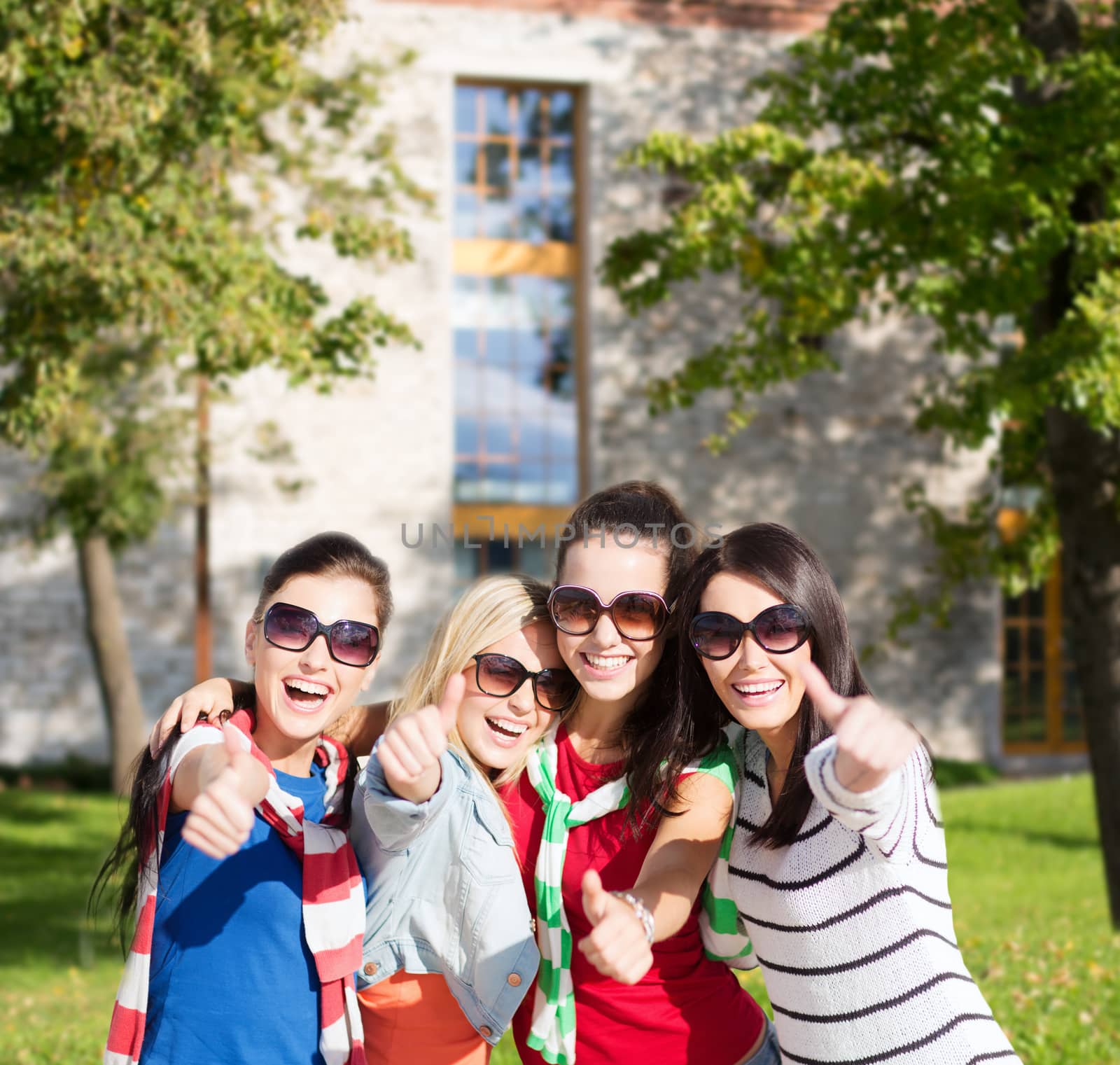 summer, holidays, vacation, happy people concept - beautiful teenage girls or young women showing thumbs up