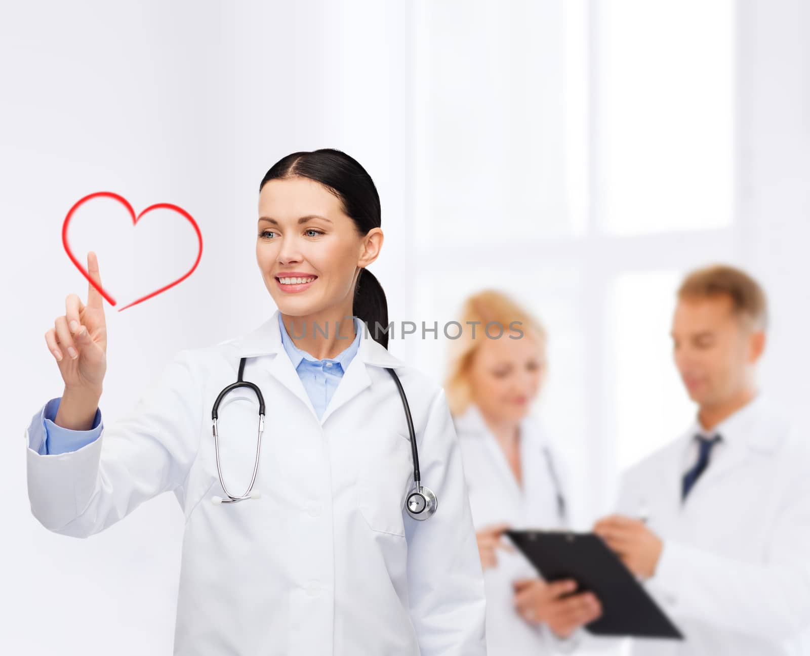 healthcare, medicine and technology concept - smiling female doctor pointing to heart