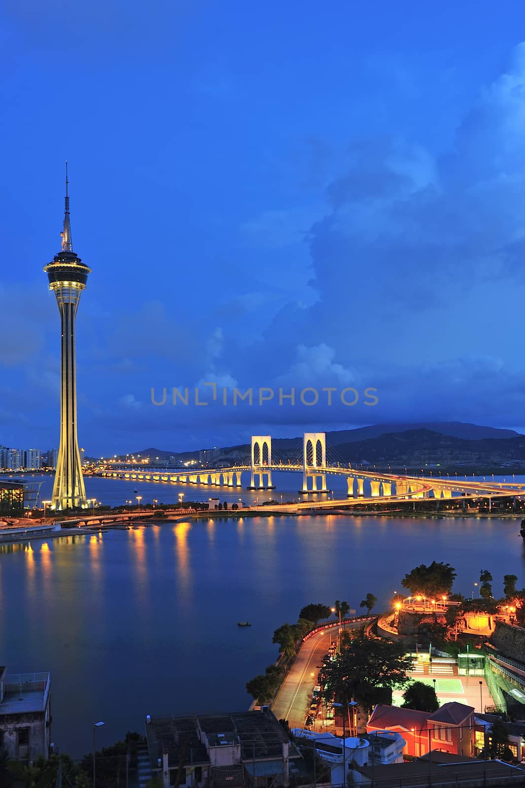 Urban landscape of Macau with famous traveling tower under blue sky near river in Macao, Asia.