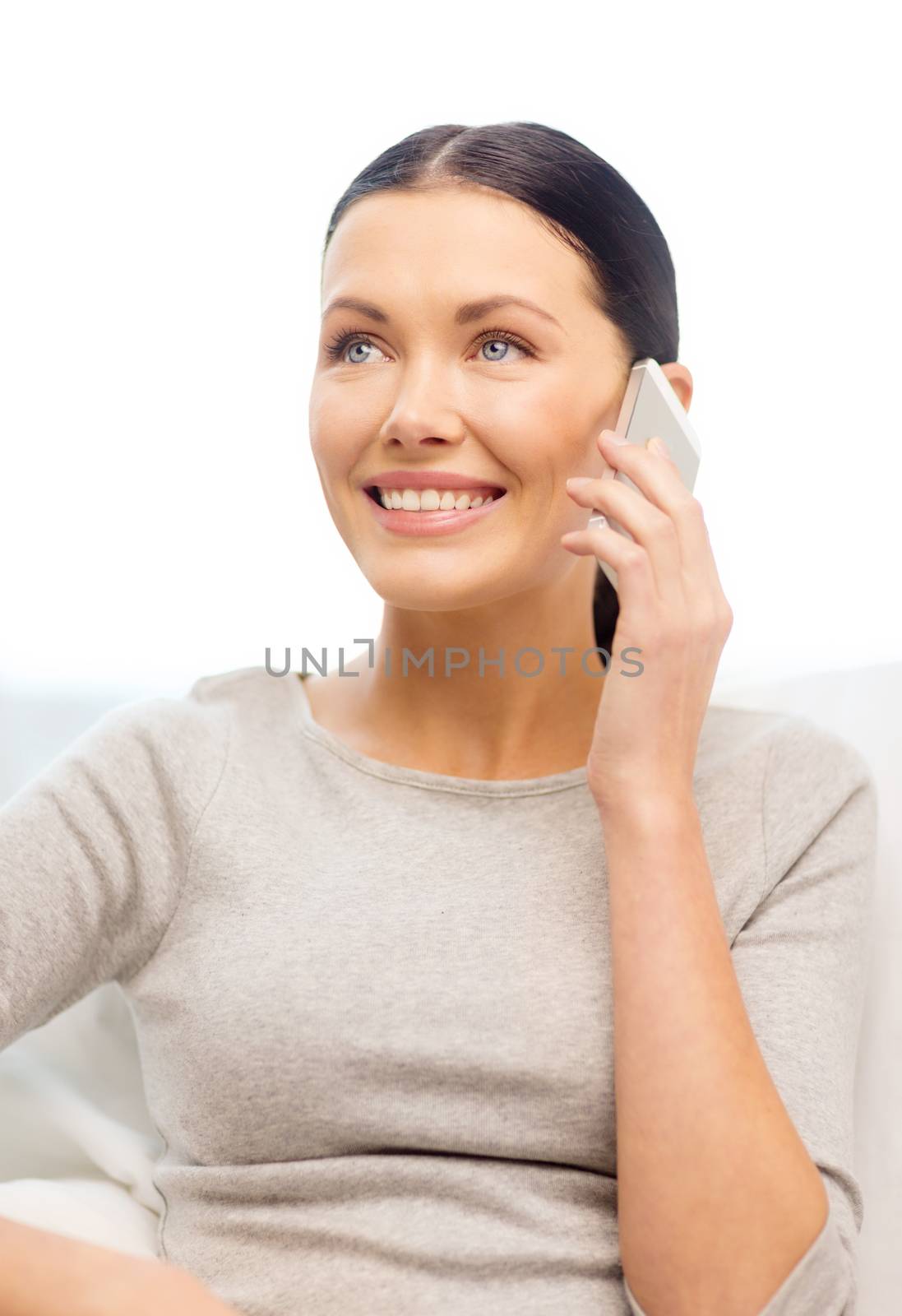 home, technology, communication and internet concept - woman sitting on the couch with smartphone at home