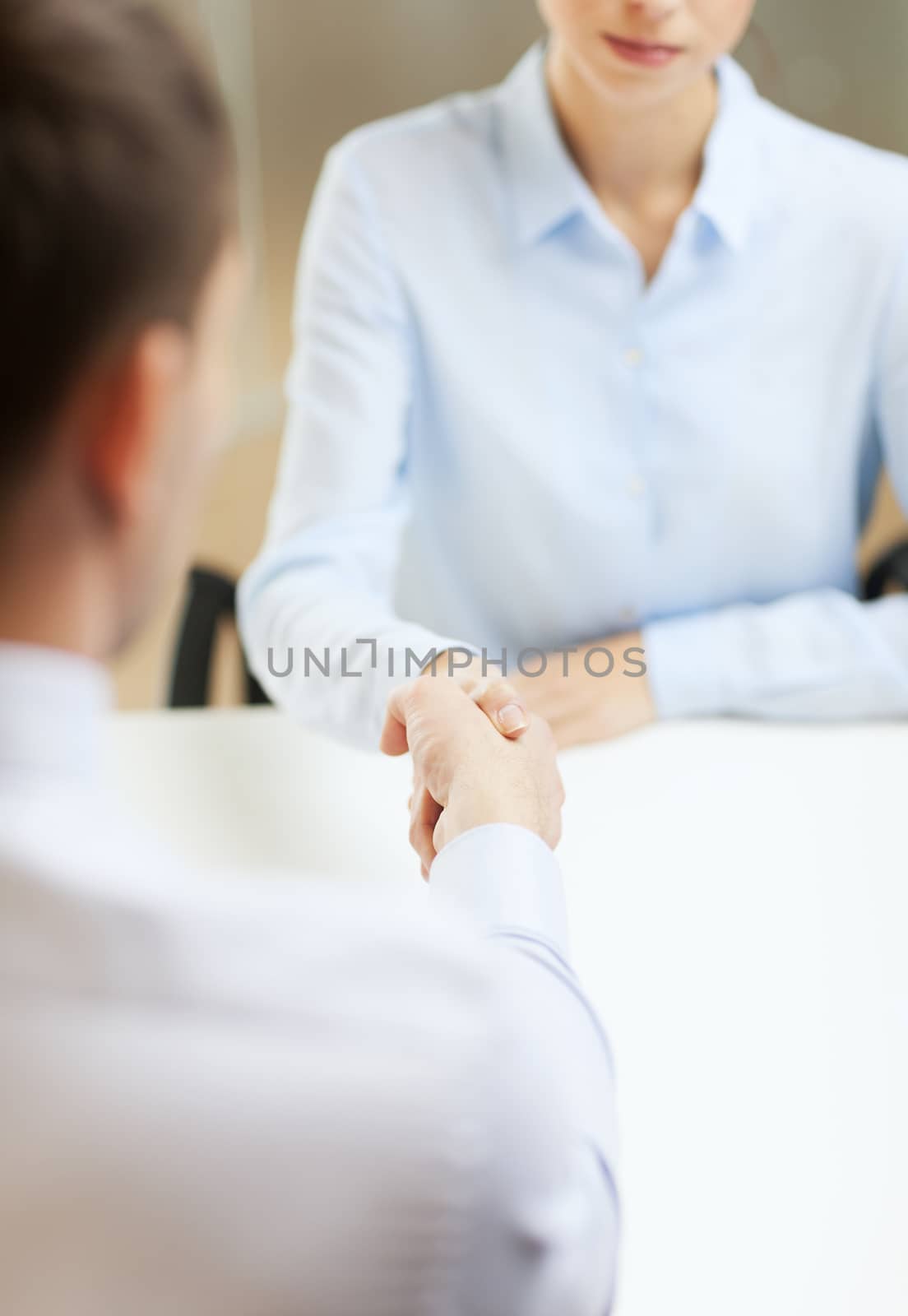 business and office concept - businesswoman and businessman shaking hands in office