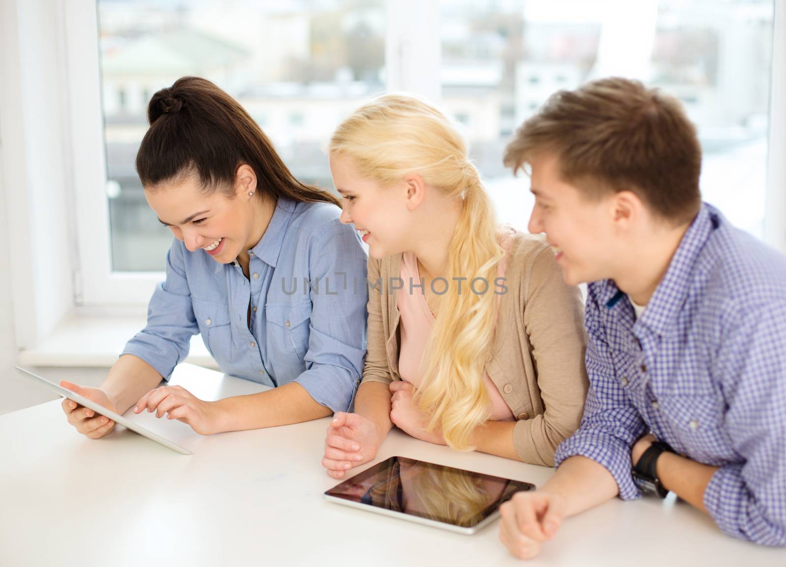 smiling students with tablet pc computer at school by dolgachov