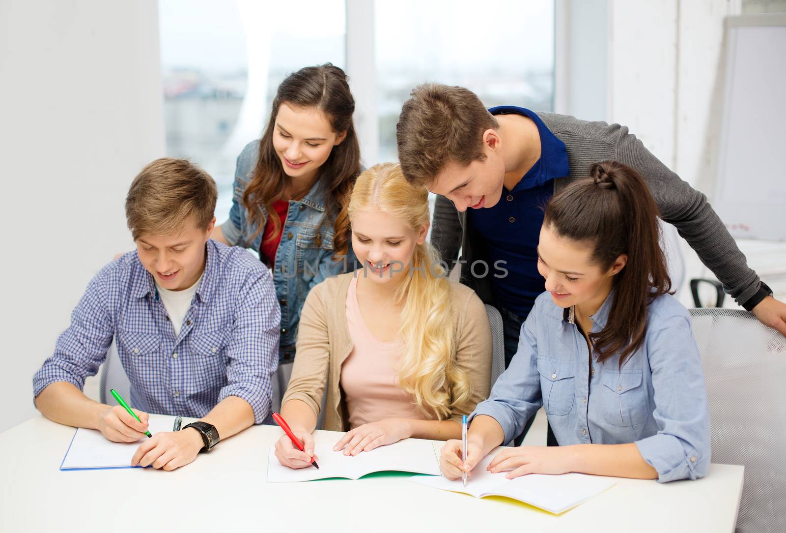 school and education concept - group of smiling students with notebooks at school