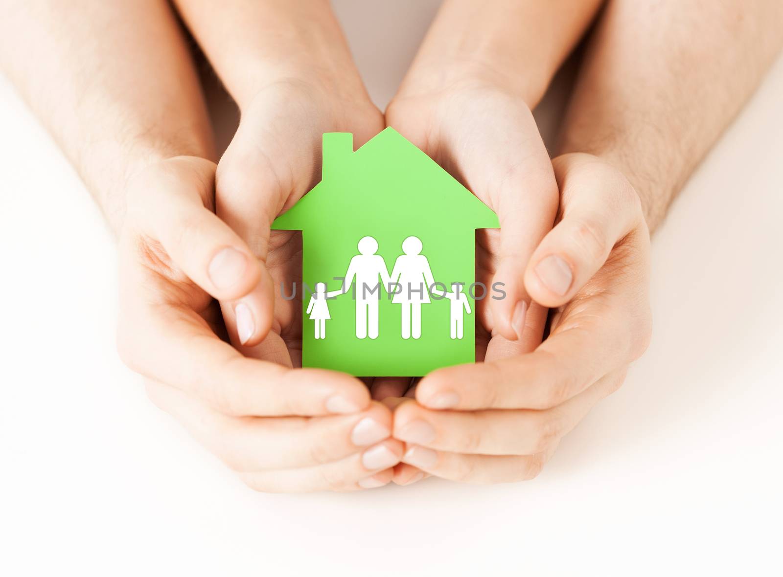 hands holding green house with family by dolgachov