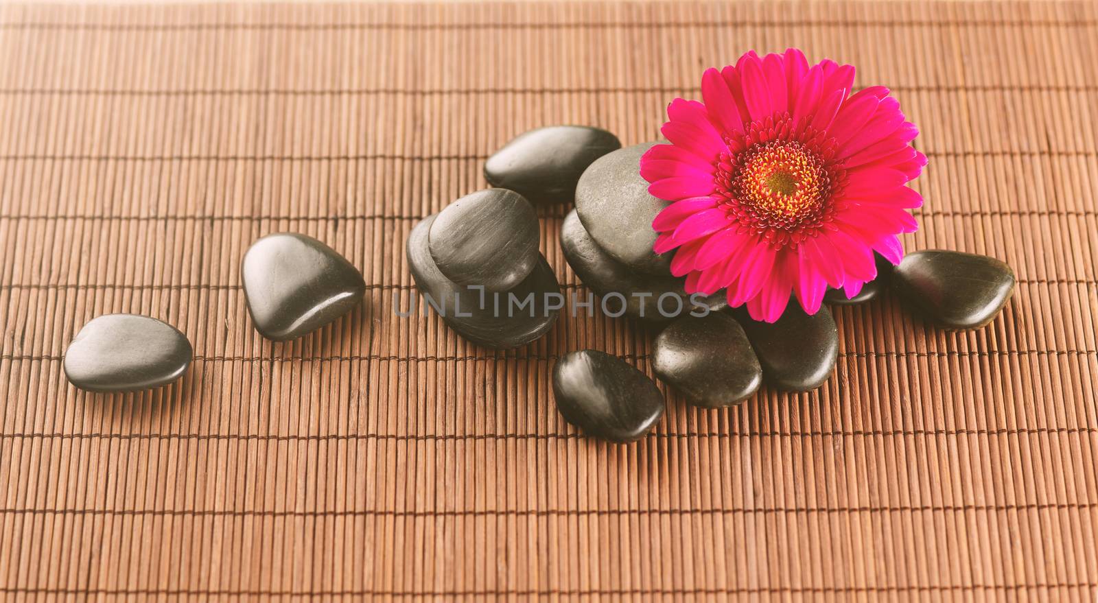 massage stones with flower on mat by dolgachov