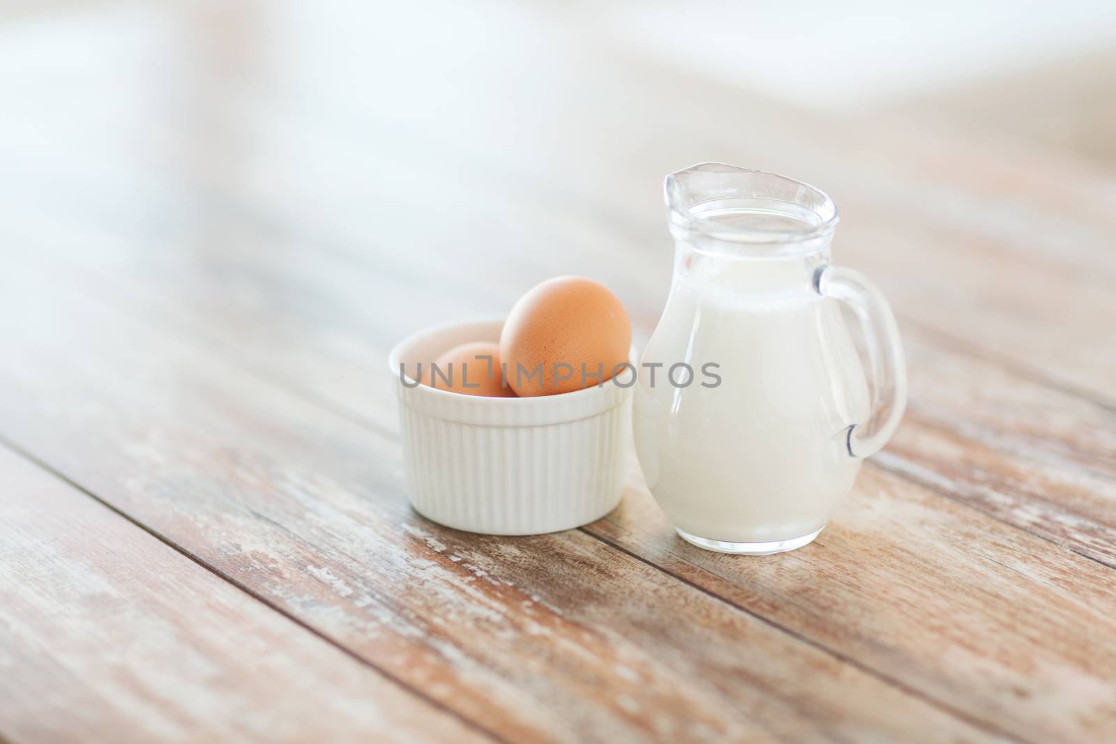 close up of jugful of milk and eggs in a bowl by dolgachov