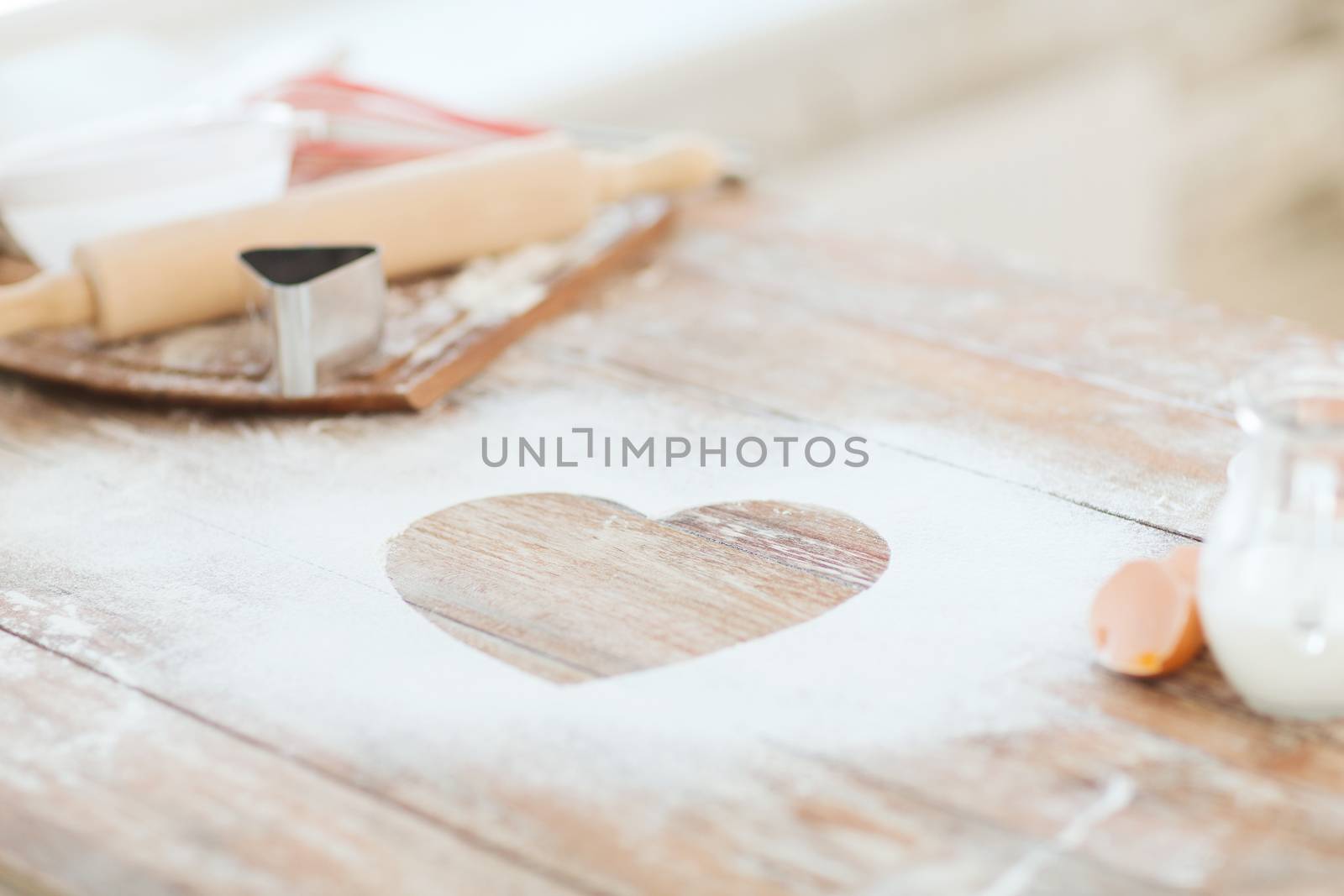 close up of heart of flour on wooden table at home by dolgachov