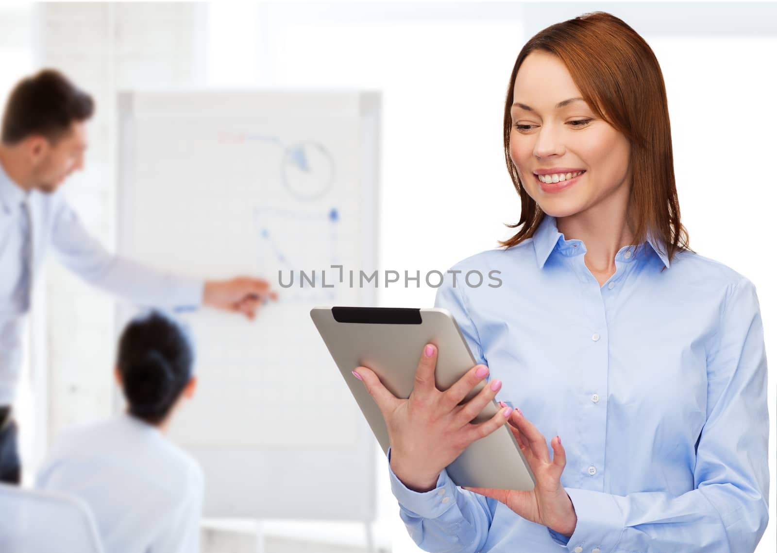 smiling woman looking at tablet pc at office by dolgachov