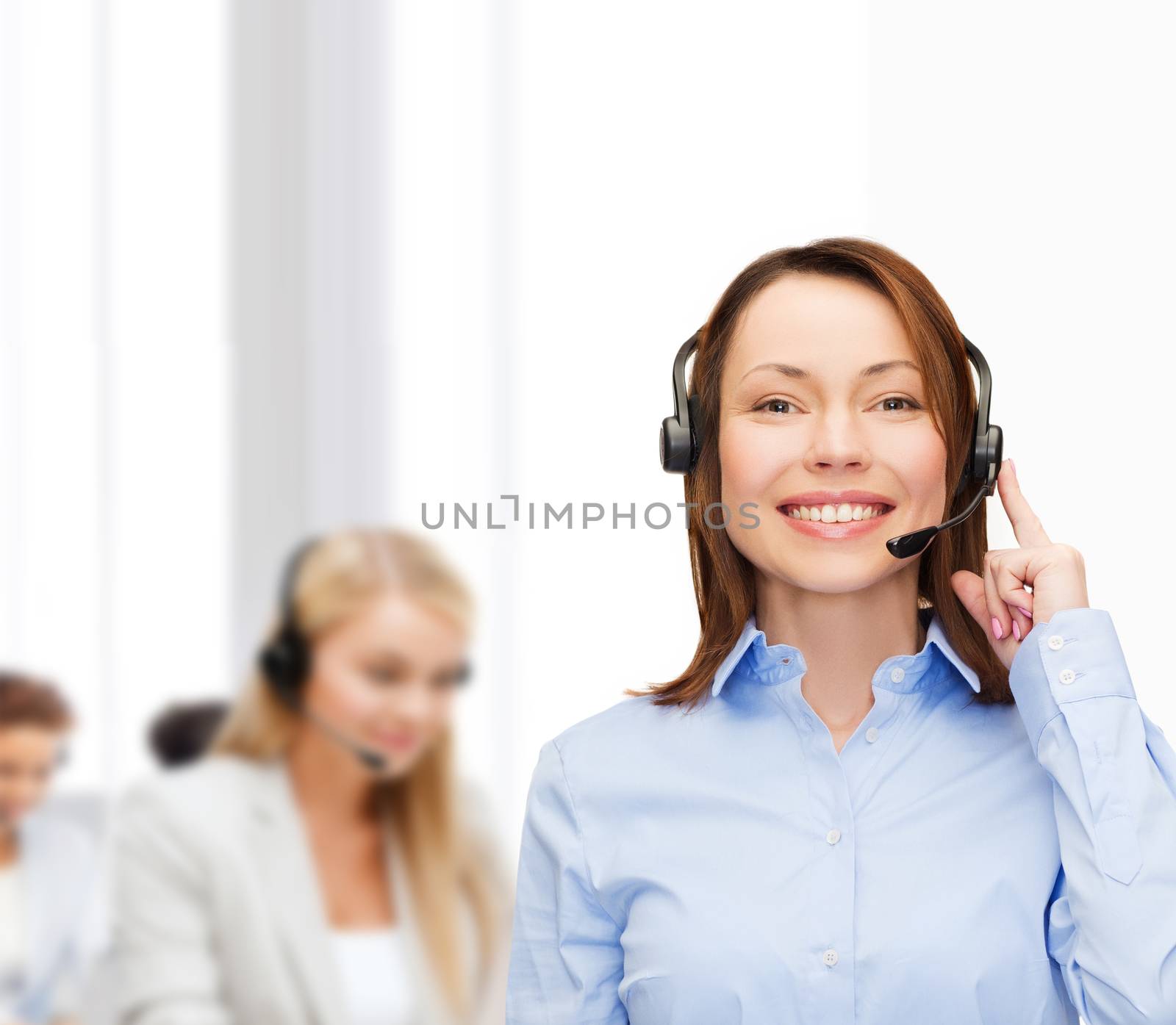 business, technology and call center concept - friendly female helpline operator with headphones at office