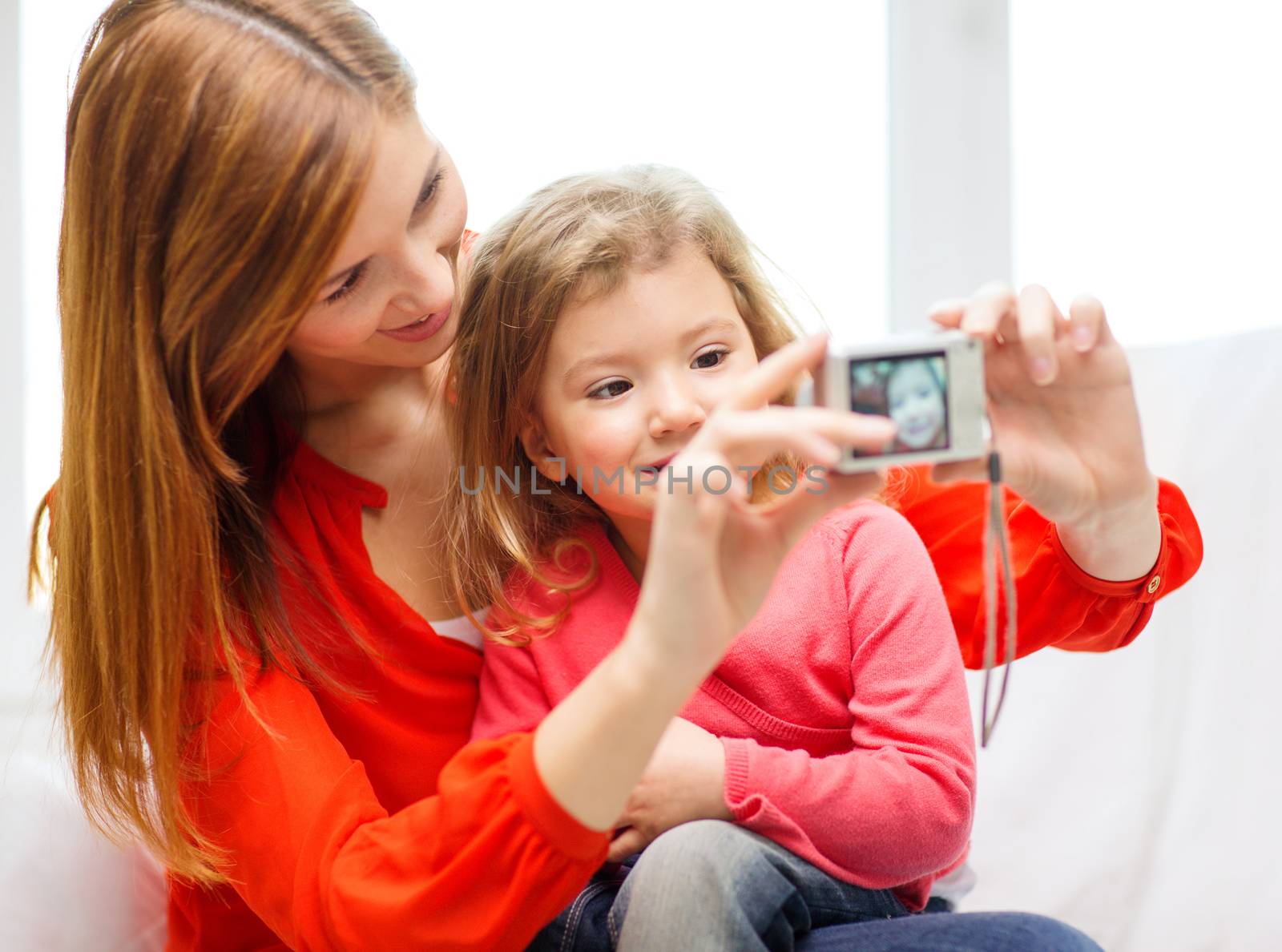 family, children, technology and happy people concept - smiling mother and daughter with digital camera