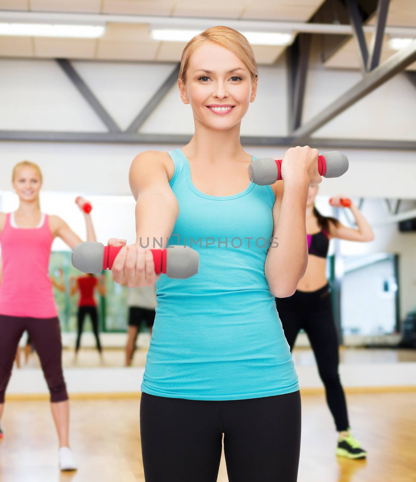 sport, excercising and healthcare concept - young sporty woman with light dumbbells