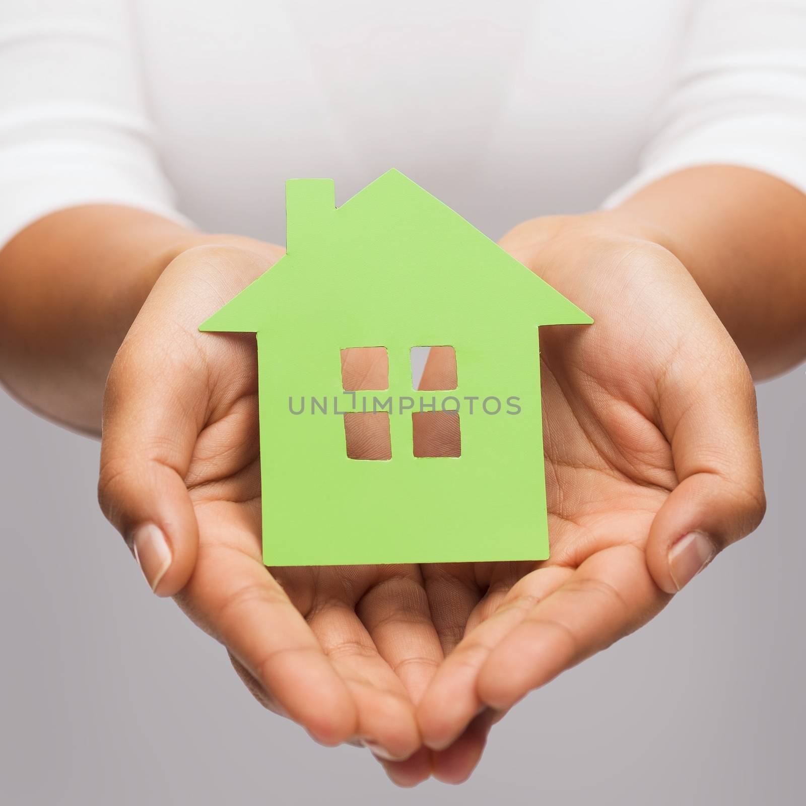 real estate and eco concept - closeup picture of woman hands holding green house