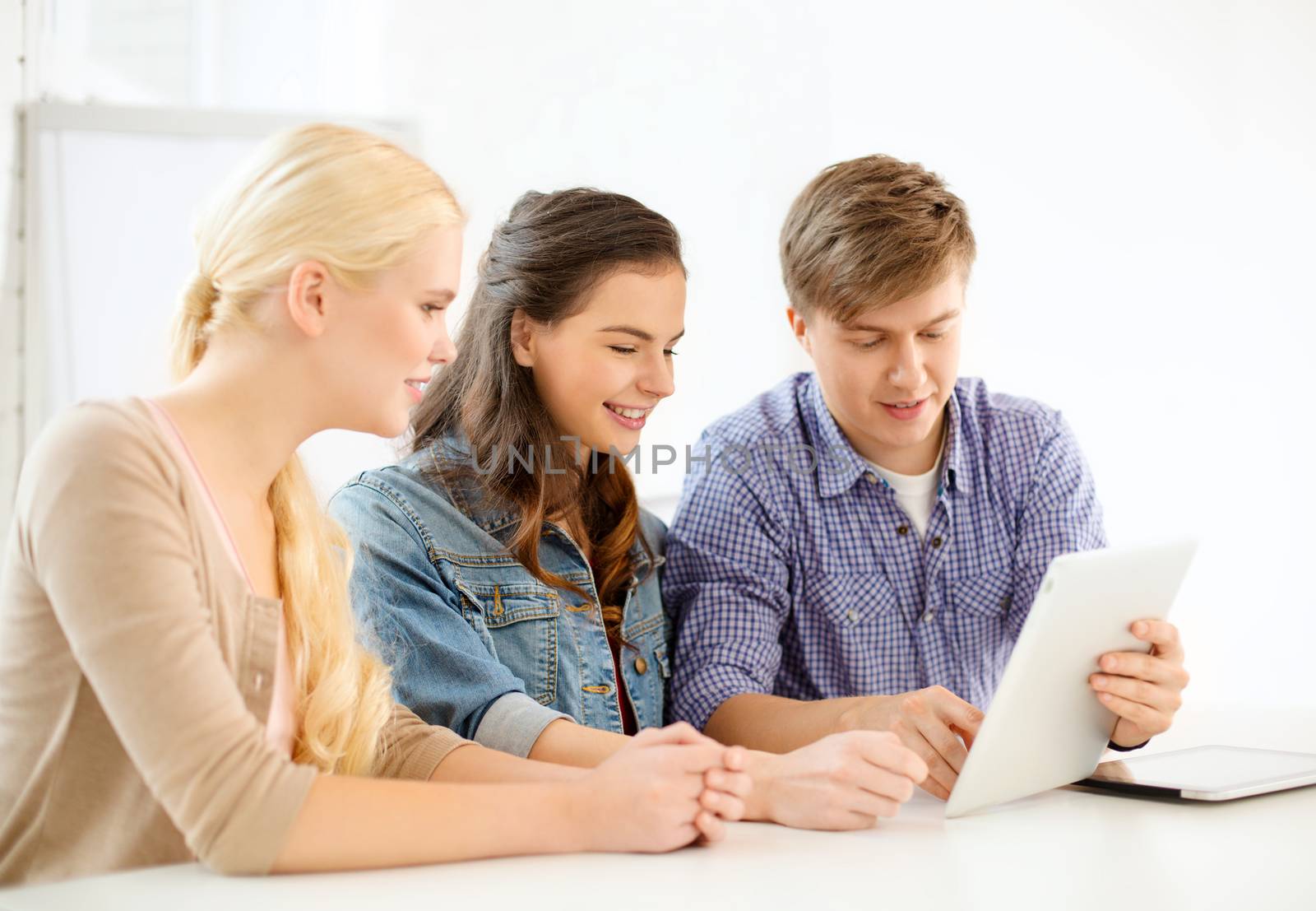 smiling students with tablet pc computer at school by dolgachov