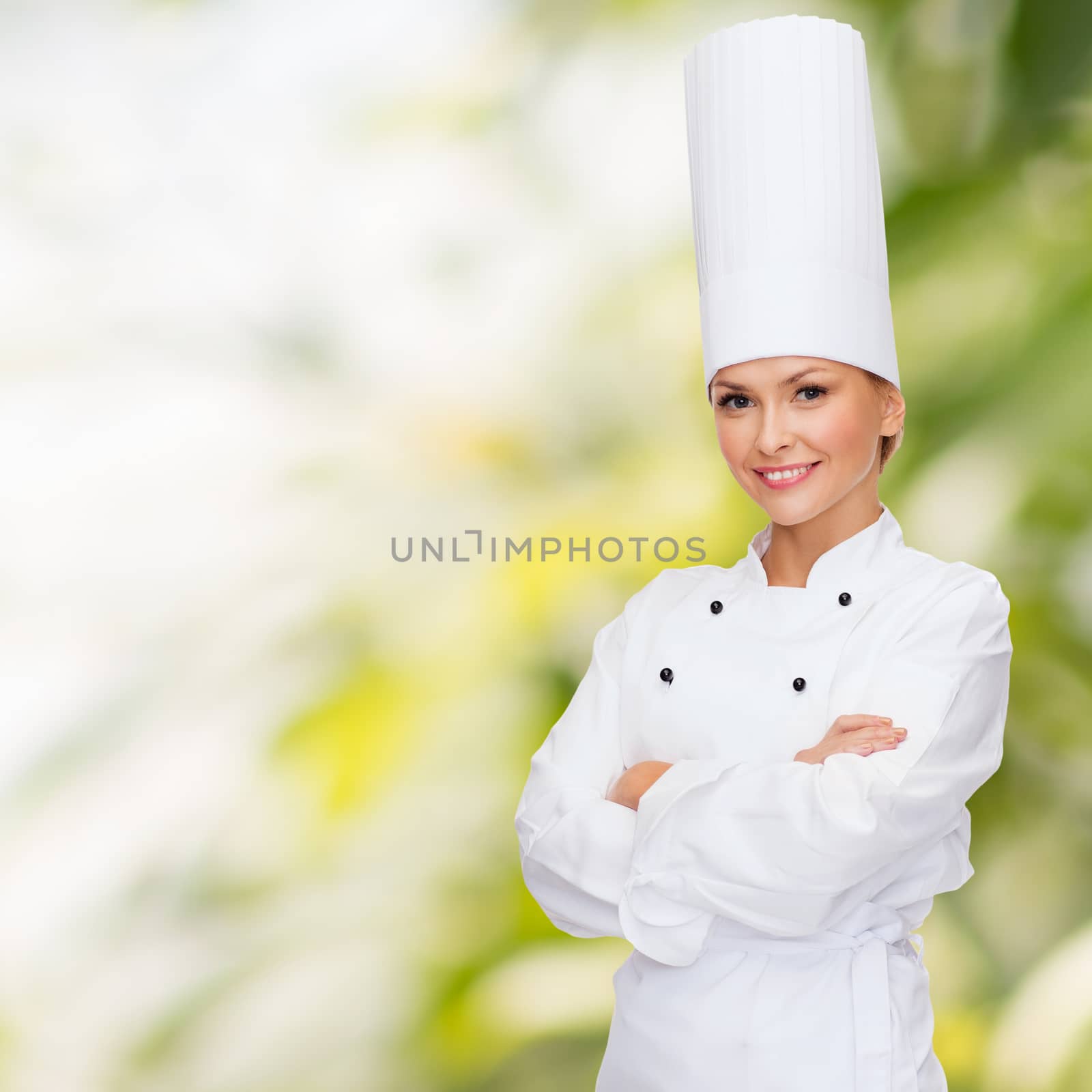 smiling female chef with crossed arms by dolgachov
