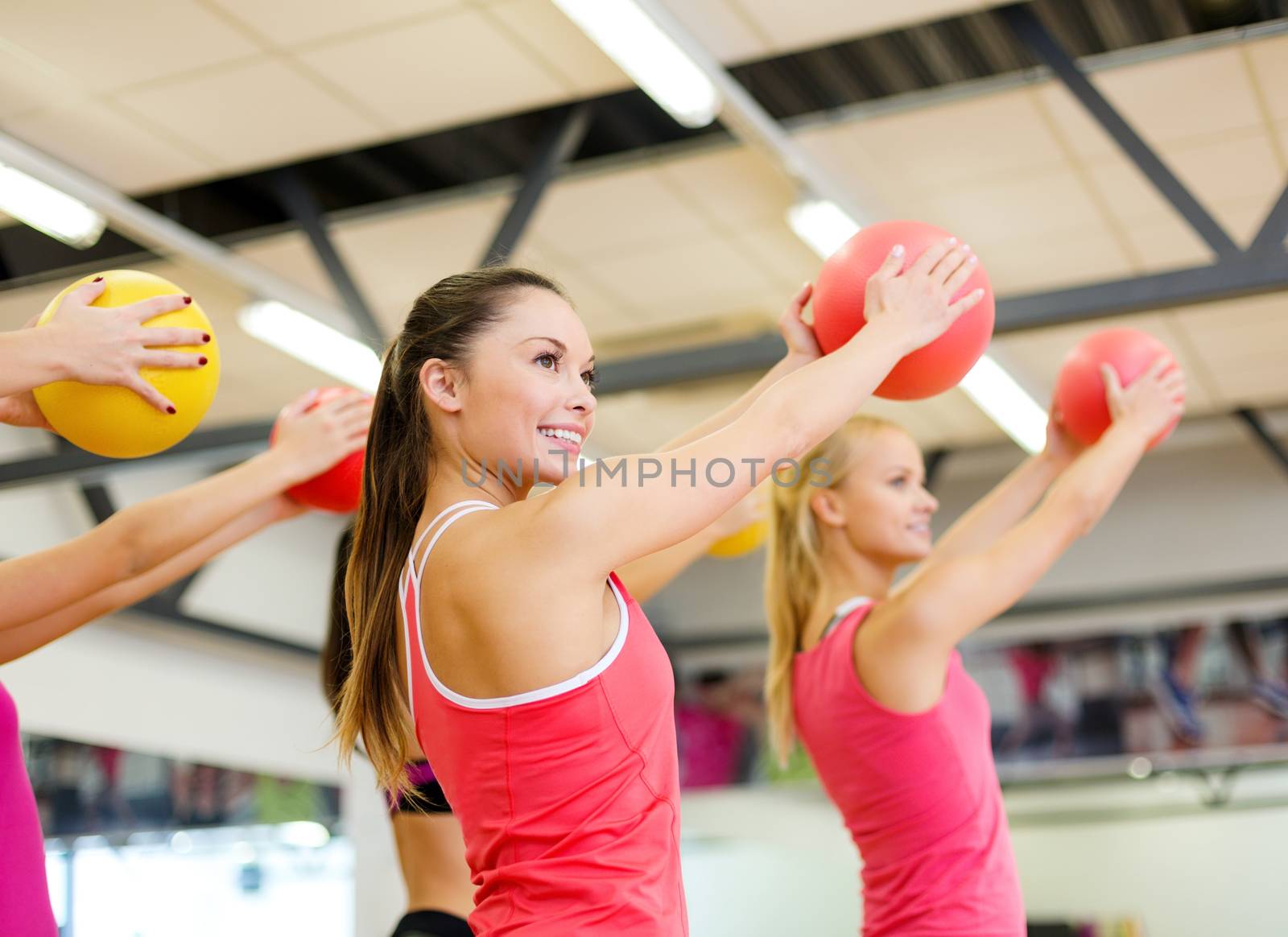 fitness, sport, training, gym and lifestyle concept - group of smiling people working out with stability balls in the gym