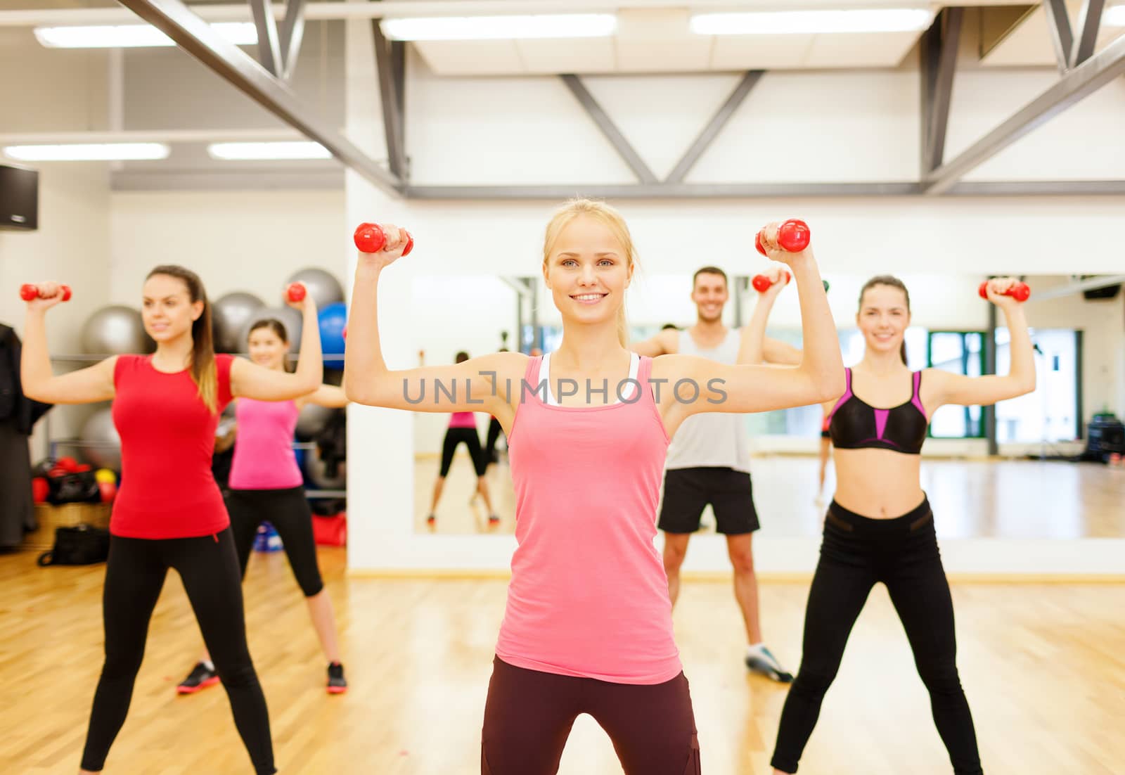 group of smiling people working out with dumbbells by dolgachov