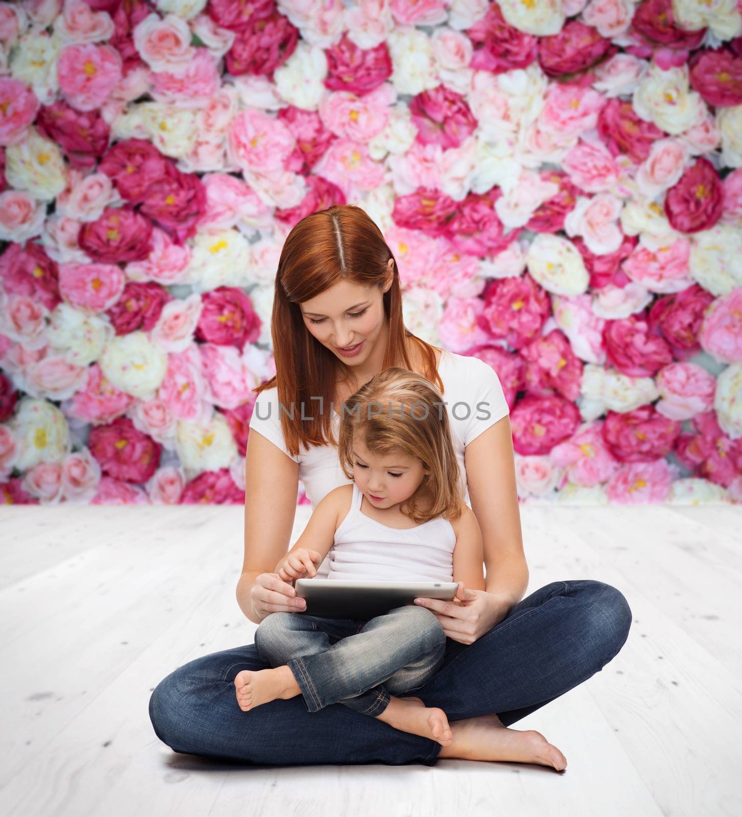 childhood, parenting and technology concept - happy mother with adorable little girl and tablet pc computer