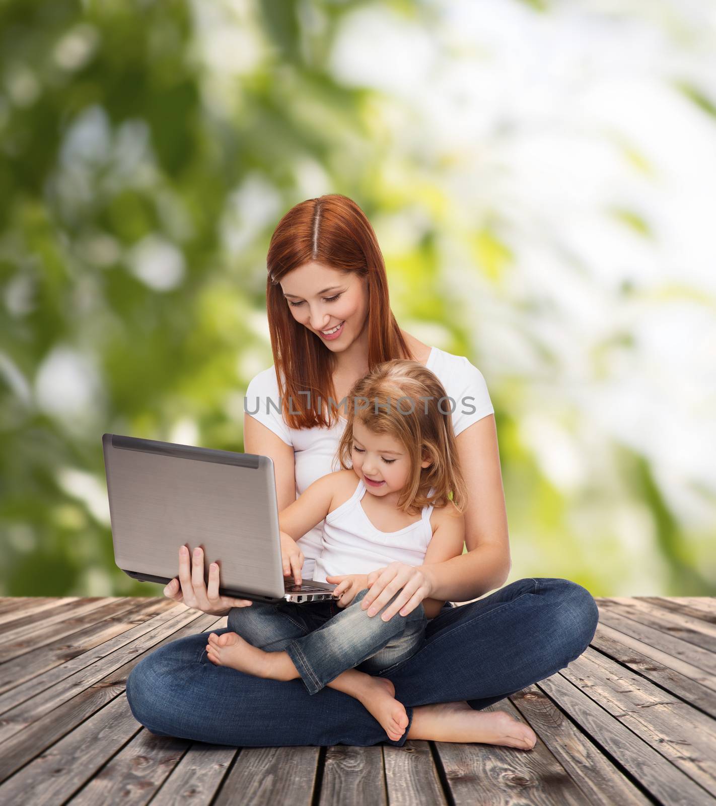 happy mother with adorable little girl and laptop by dolgachov