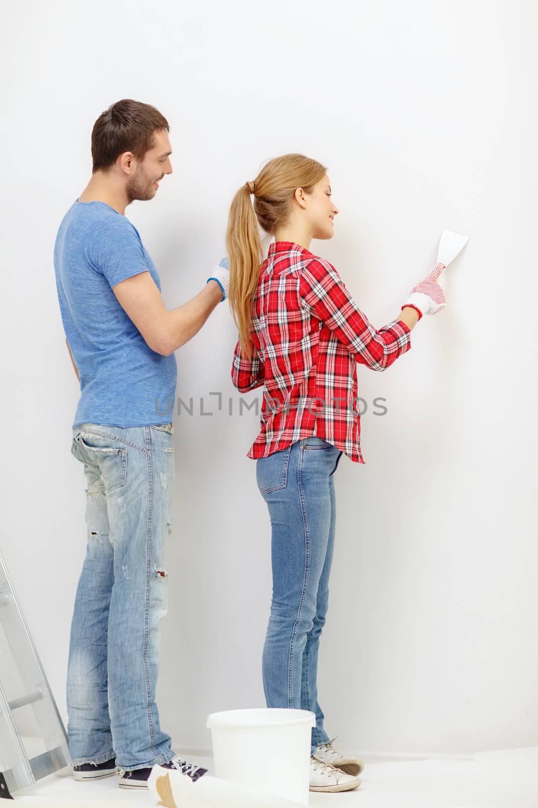 repair, renovation and home concept - smiling couple doing renovations at home