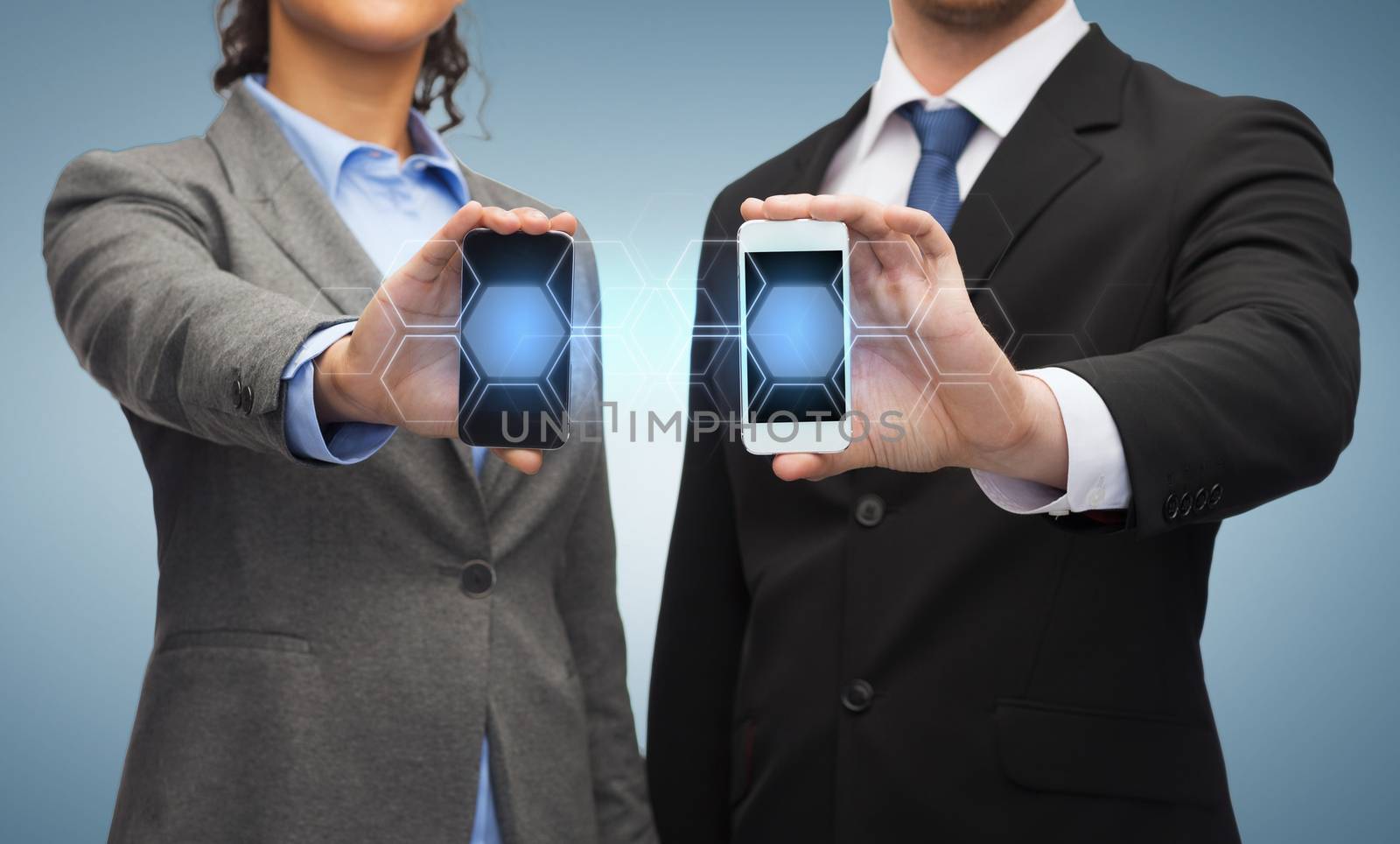 business, technology and internetconcept - businessman and businesswoman with blank black smartphone screens