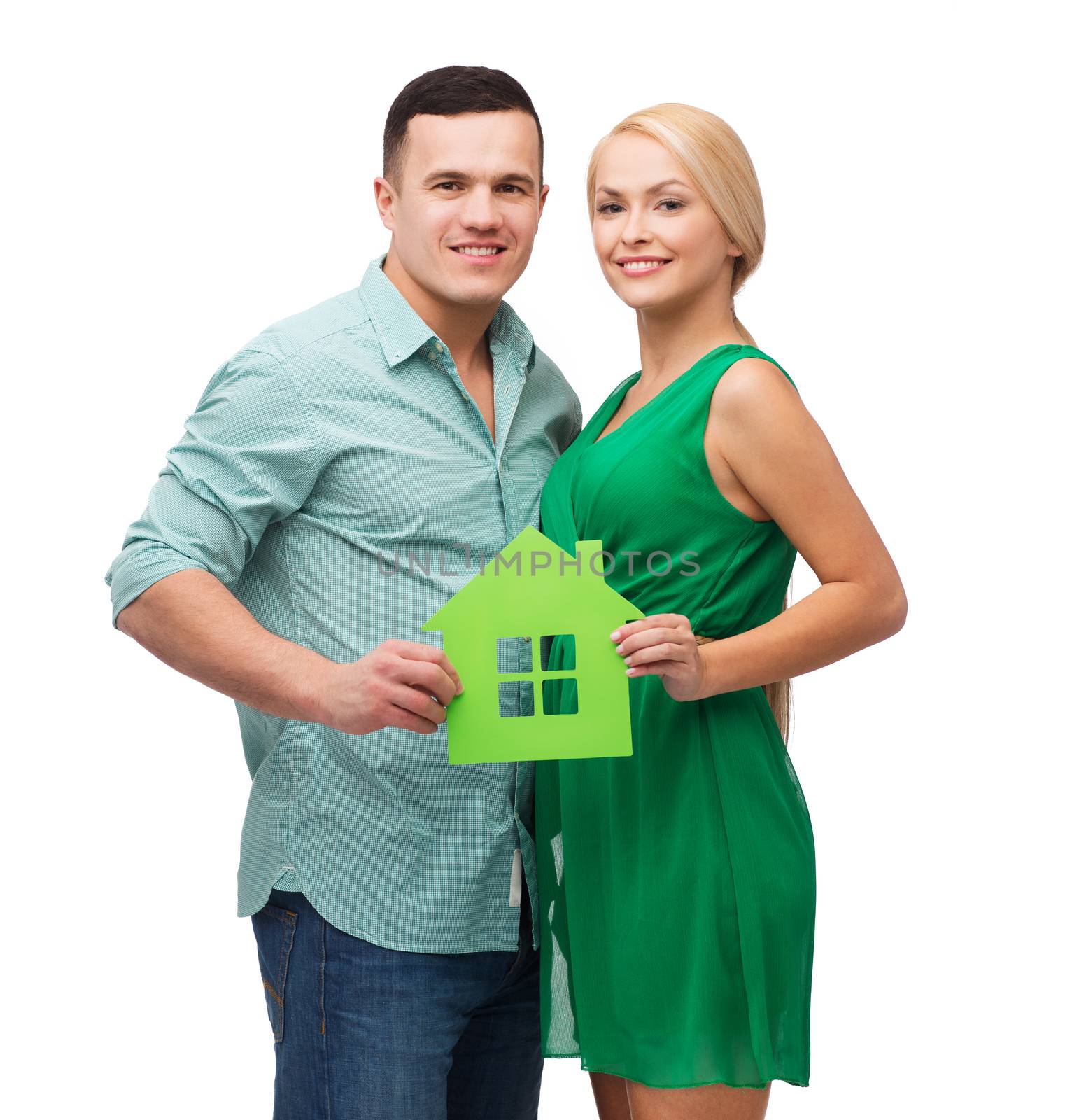 smiling couple holding green paper house by dolgachov