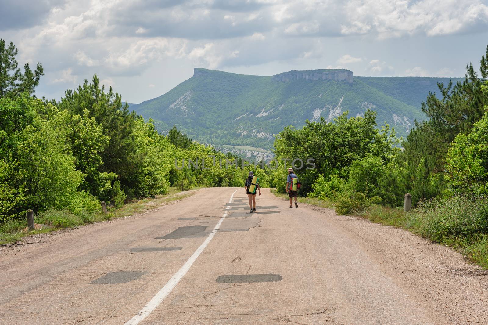 Two hiking people on the road in Crimea, Ukraine or Russia