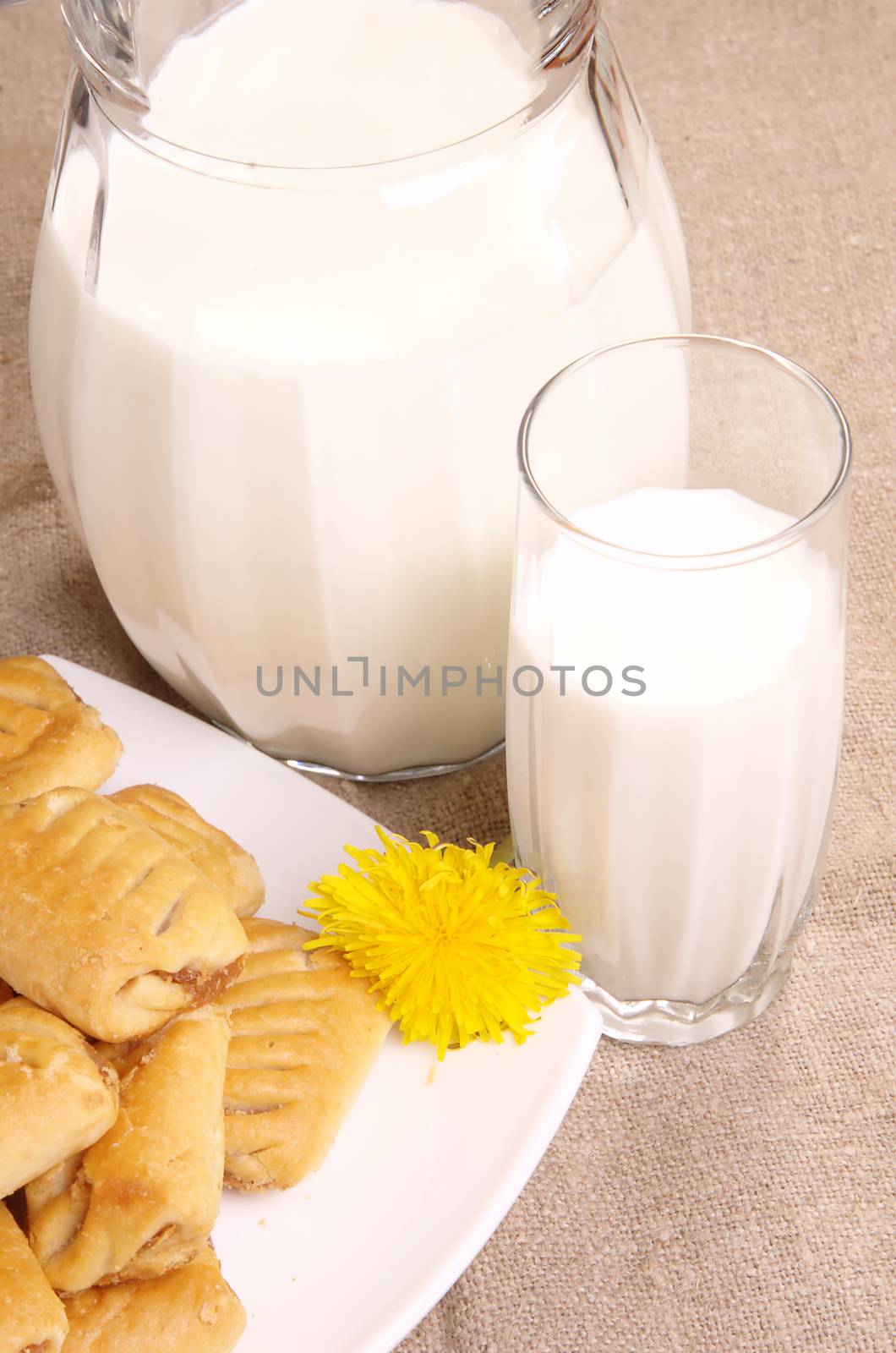 Jug with fresh milk and pastry on table