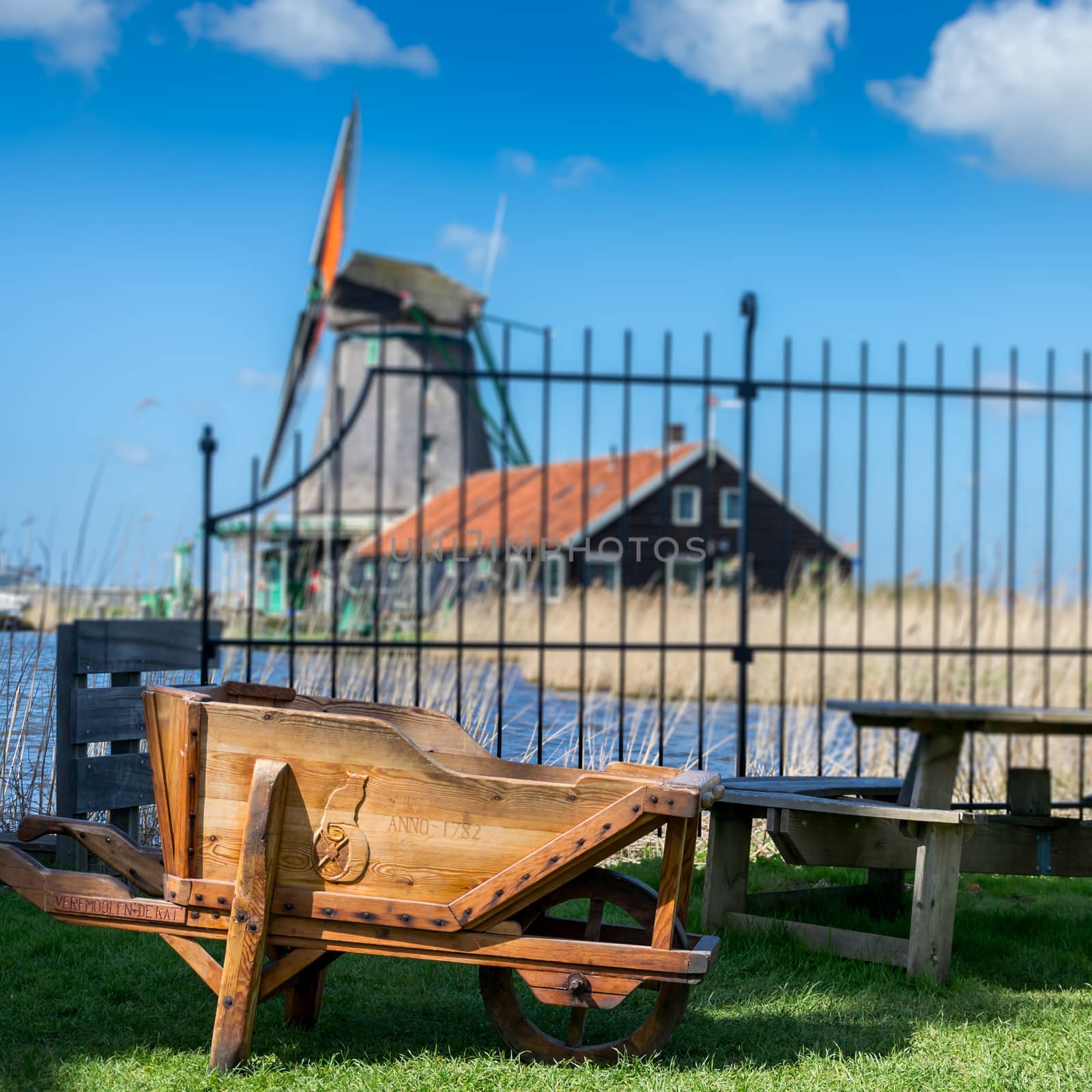 A wheelbarrow with a windmill on the background