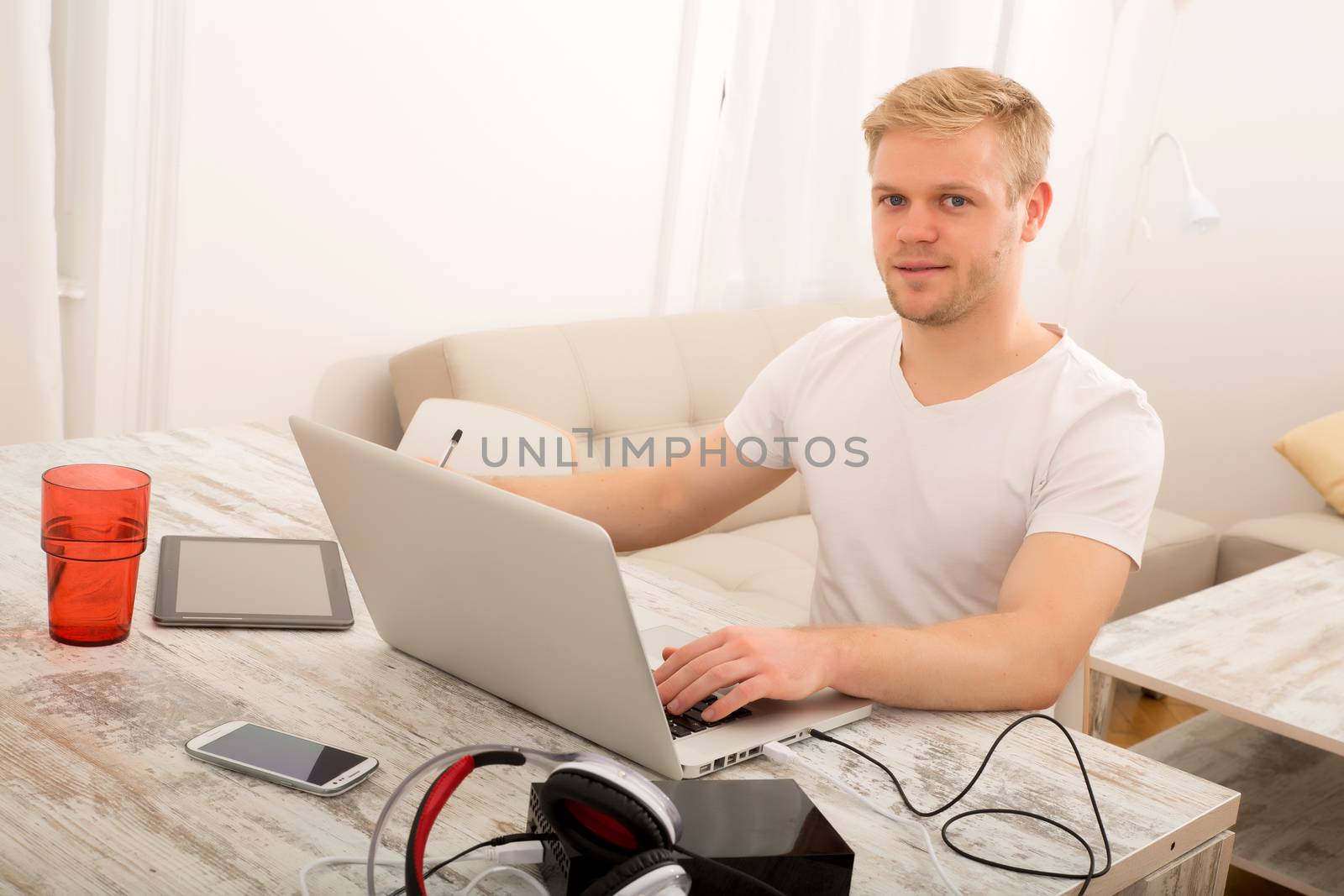 A young caucasian man working in his home office.