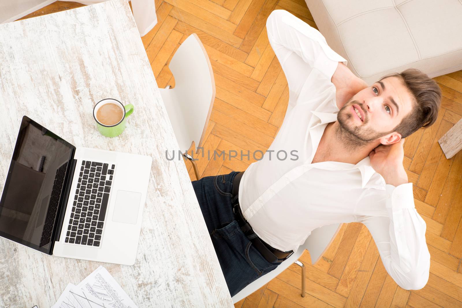 A young man working at home with a Laptop computer.